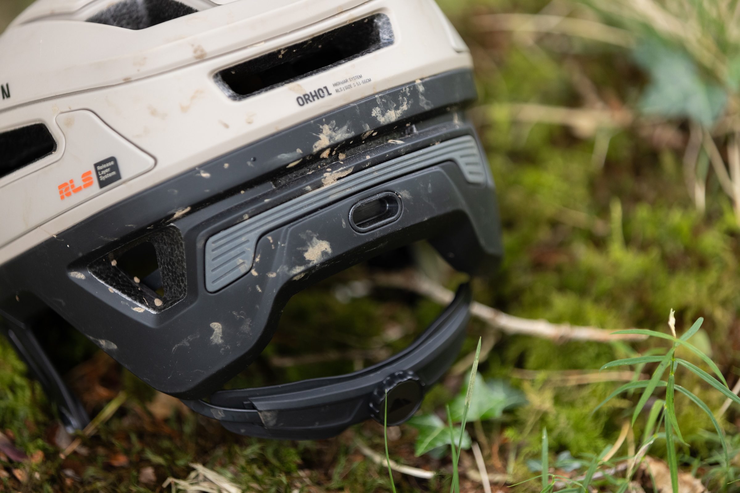 Close-up of the rear of the Canyon Deflectr mountain bike helmet showing the eyewear gripper, rear light mount and fit adjustment dial.
