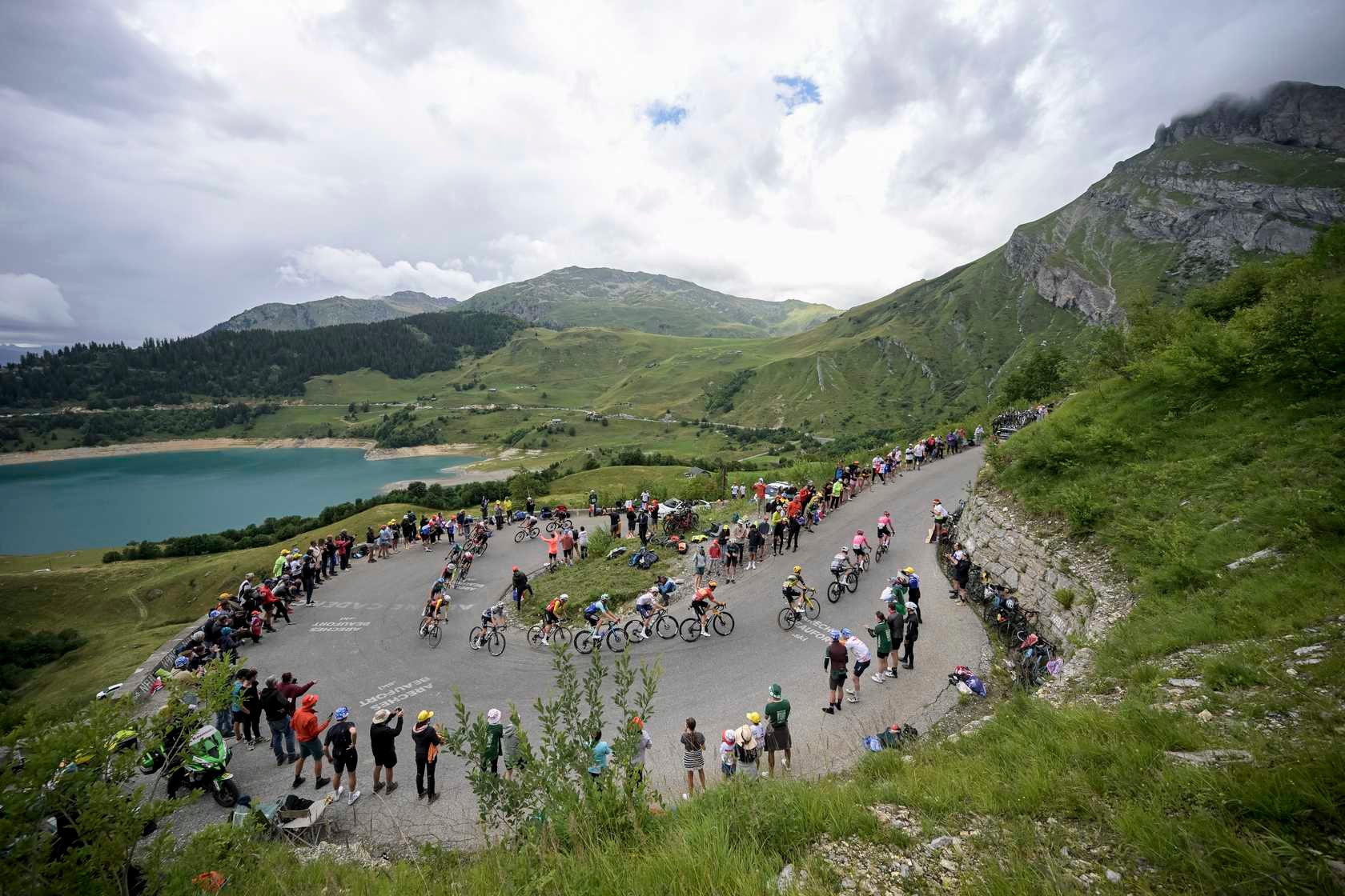 Tour de France peloton climbs mountain.