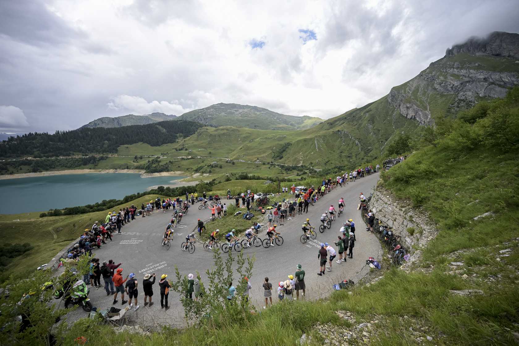 Tour de France peloton climbs mountain.