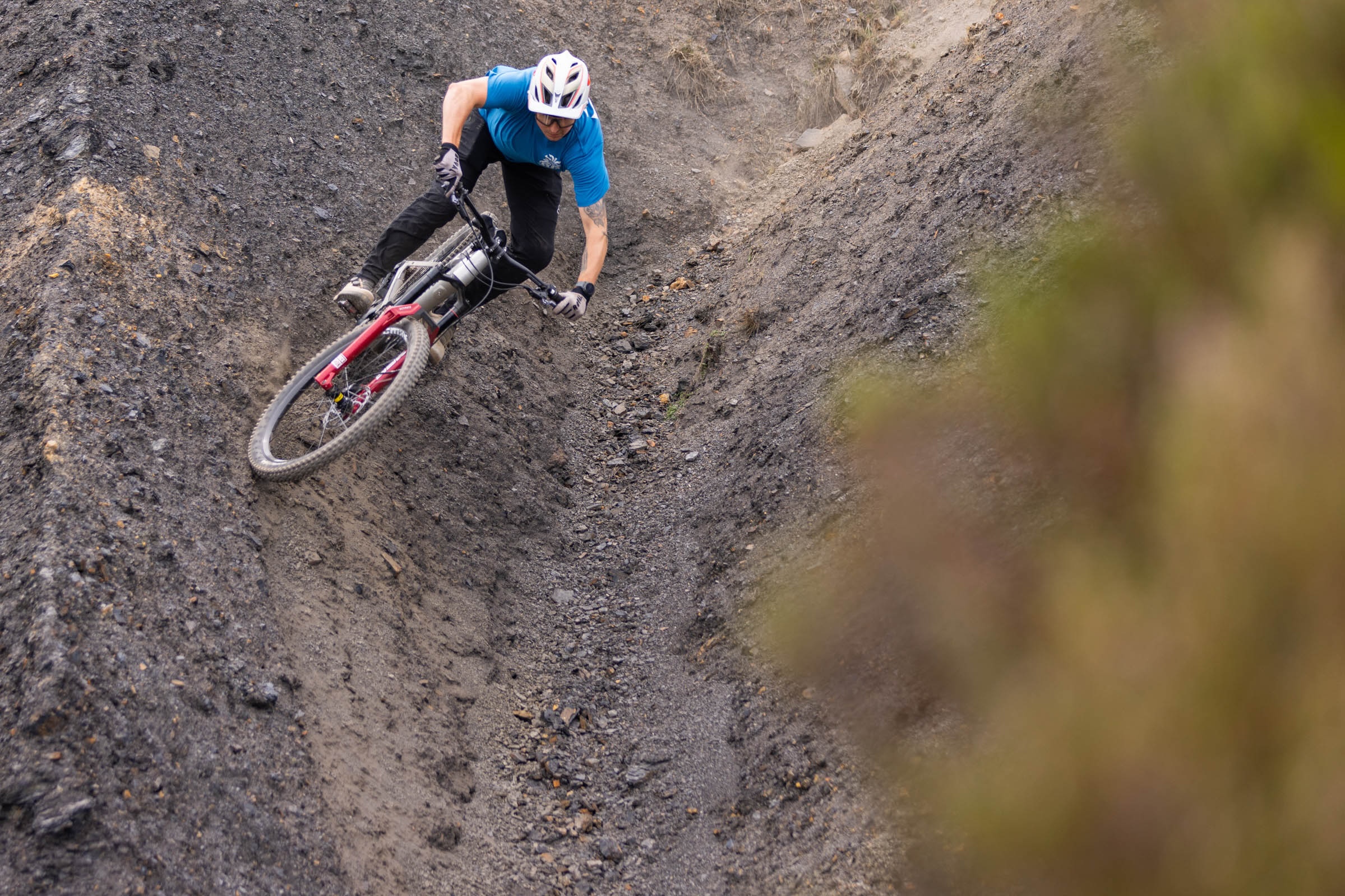 Rider leans the silver Atherton S.170E.2 through a steep, loose quarry turn