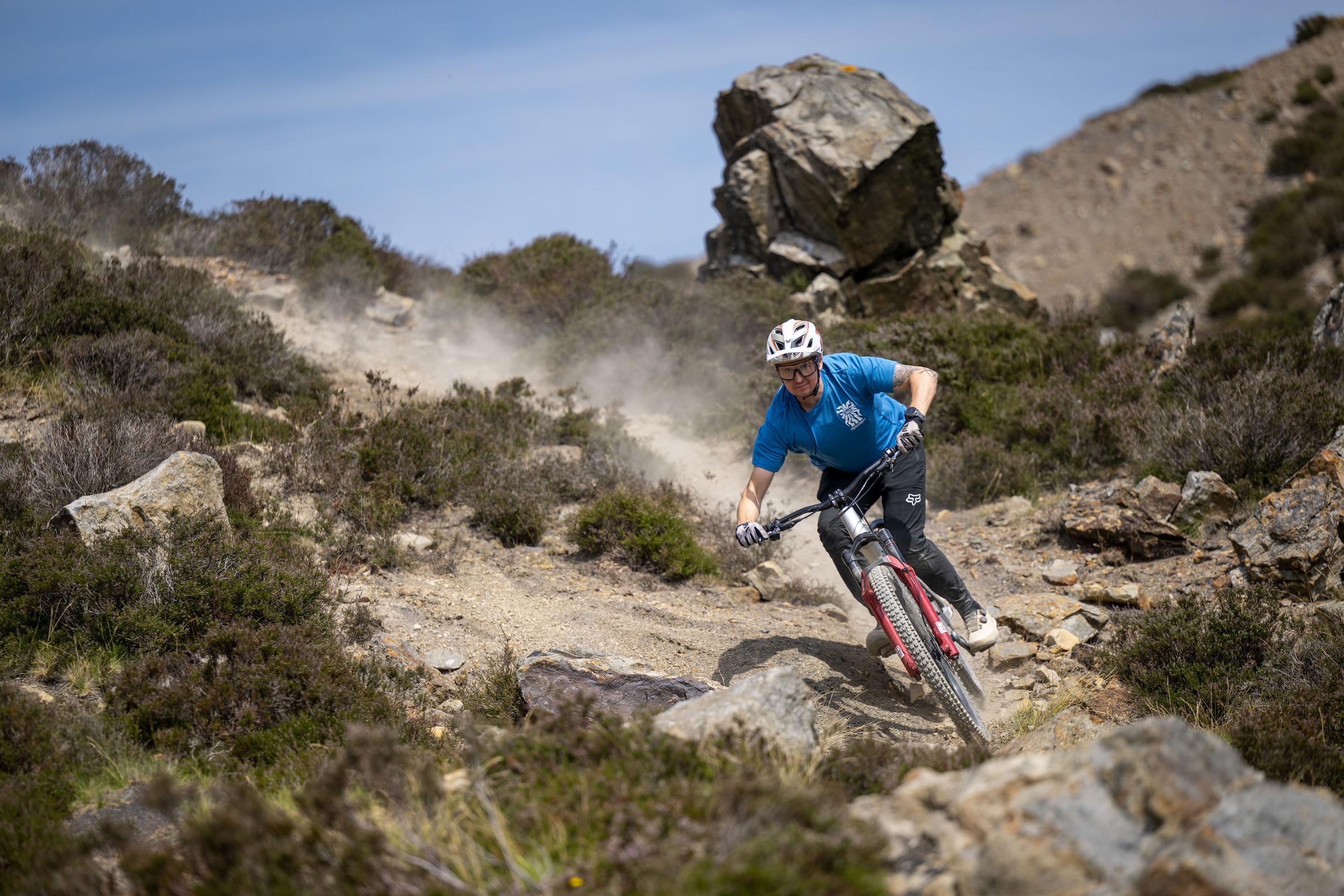 Rider corners the silver Atherton S.170E.2 through a loose, rocky trail with dust hanging behind