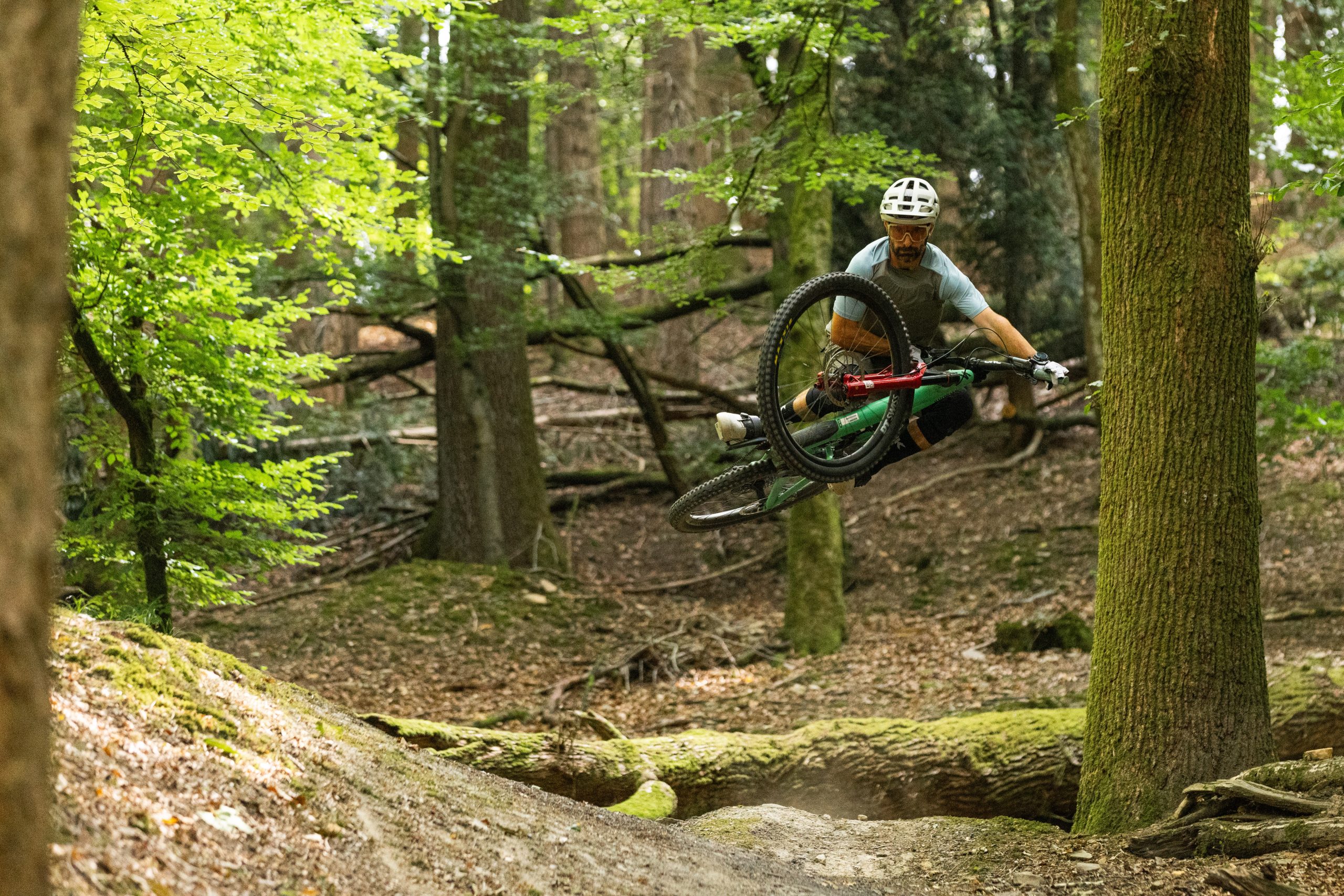 Mountain biker in the air, laying the bike flat in a table top position.
