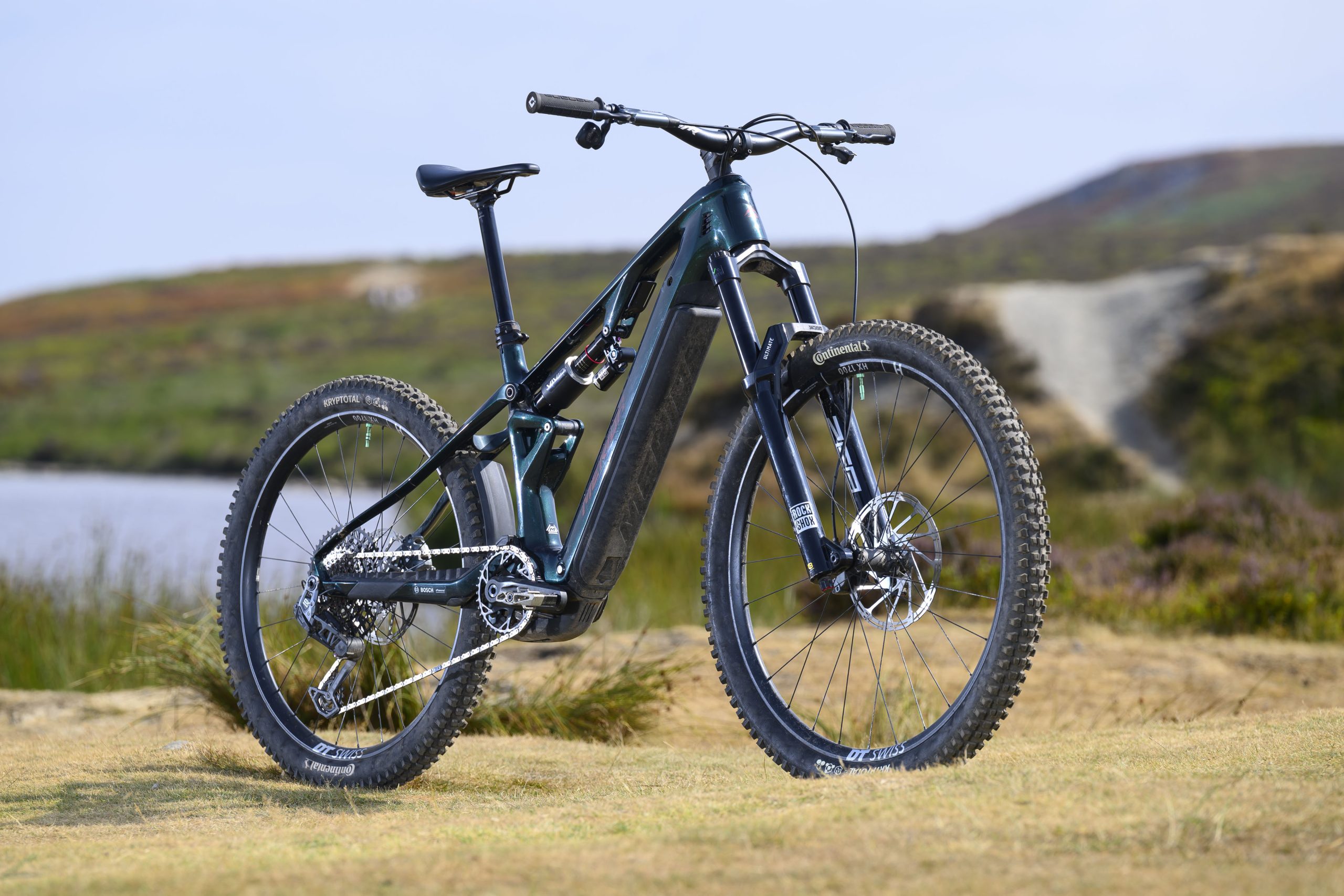Dark green Merida Lithos 8000 electric mountain bike shown from the front three-quarter angle with mixed wheels and RockShox suspension