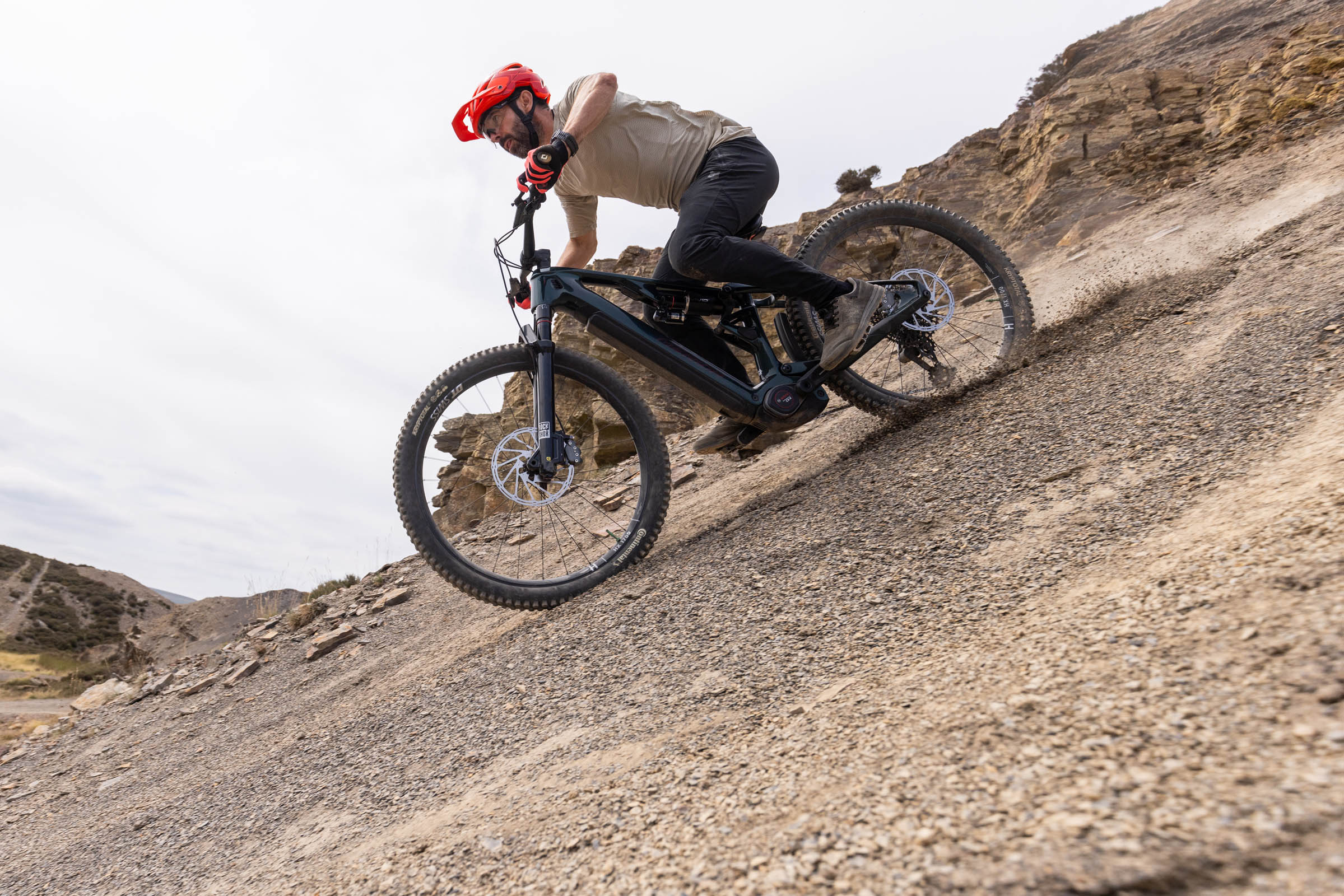 Rider lands the Merida Lithos 8000 hard into a steep, loose compression on a rocky descent