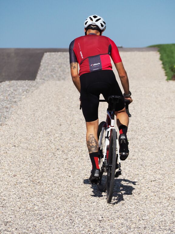 Man riding bike on gravel.