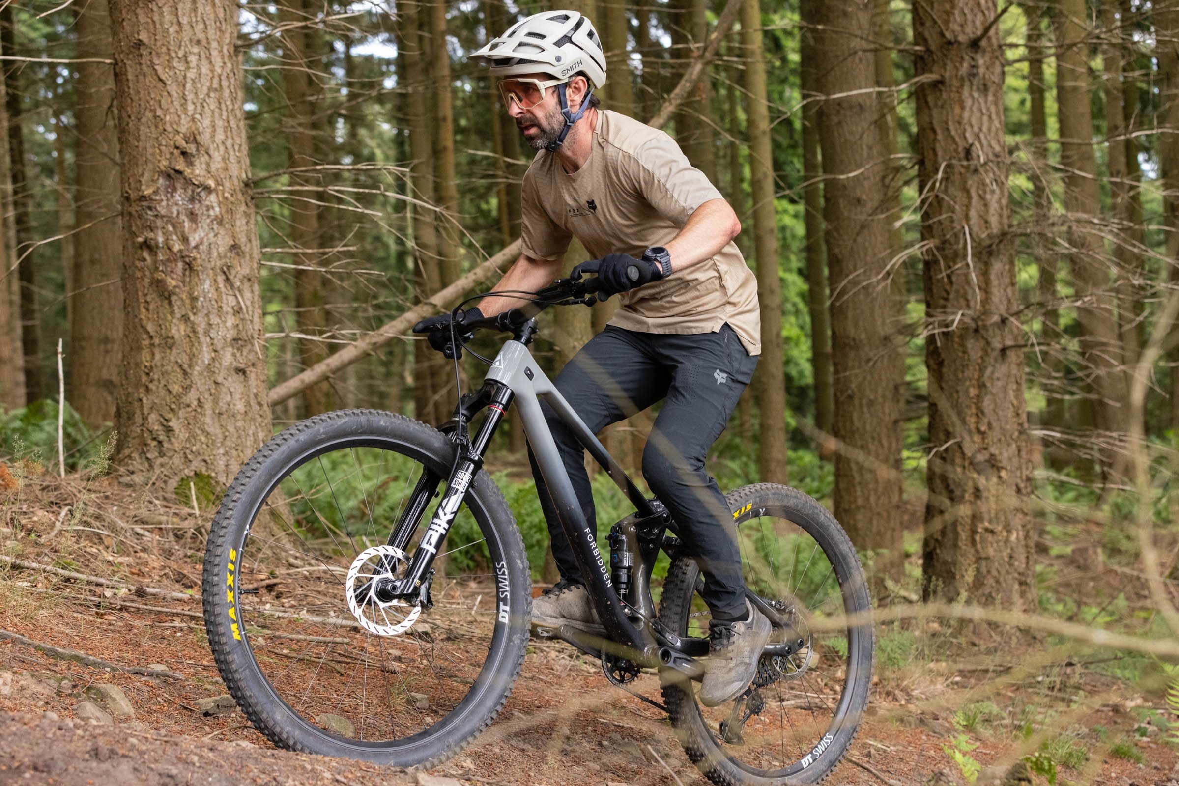 Rider in sandy coloured jersey and helmet with black trousers climbing uphill on the Forbidden Reya.