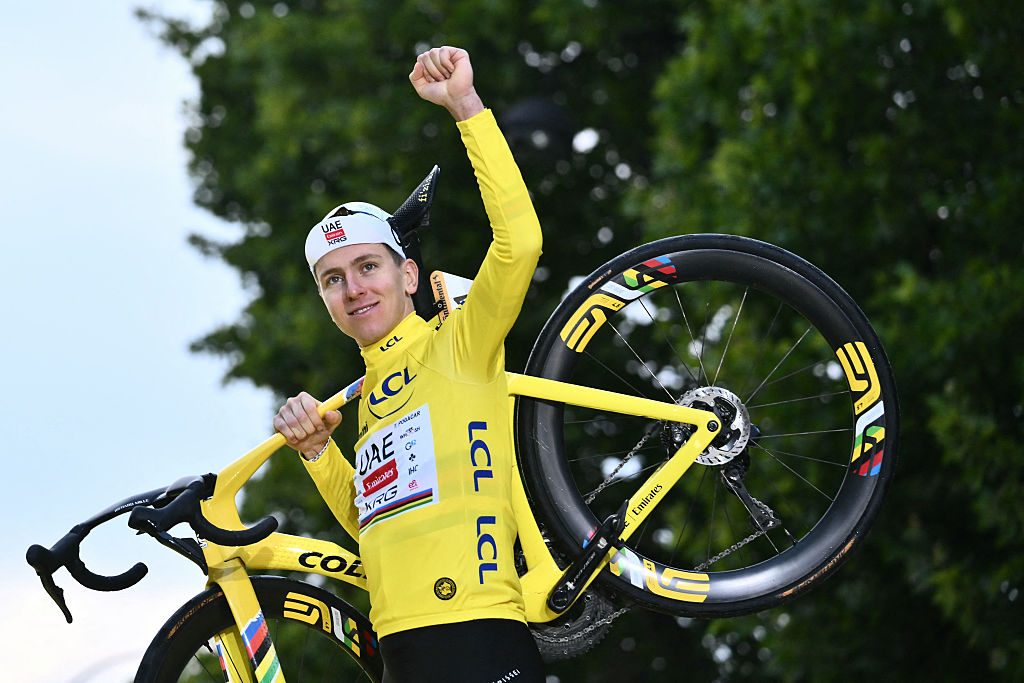 Tadej Pogacar celebrates on the podium with the overall leader's yellow jersey at TDF 2025
