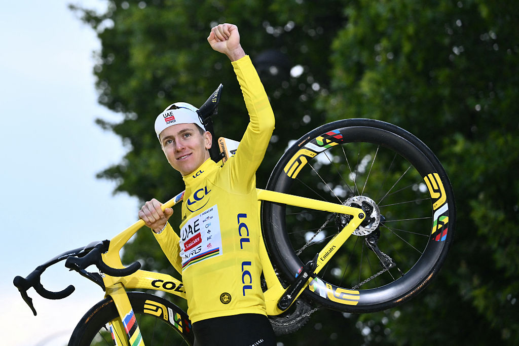 Tadej Pogacar celebrates on the podium with the overall leader's yellow jersey at TDF 2025