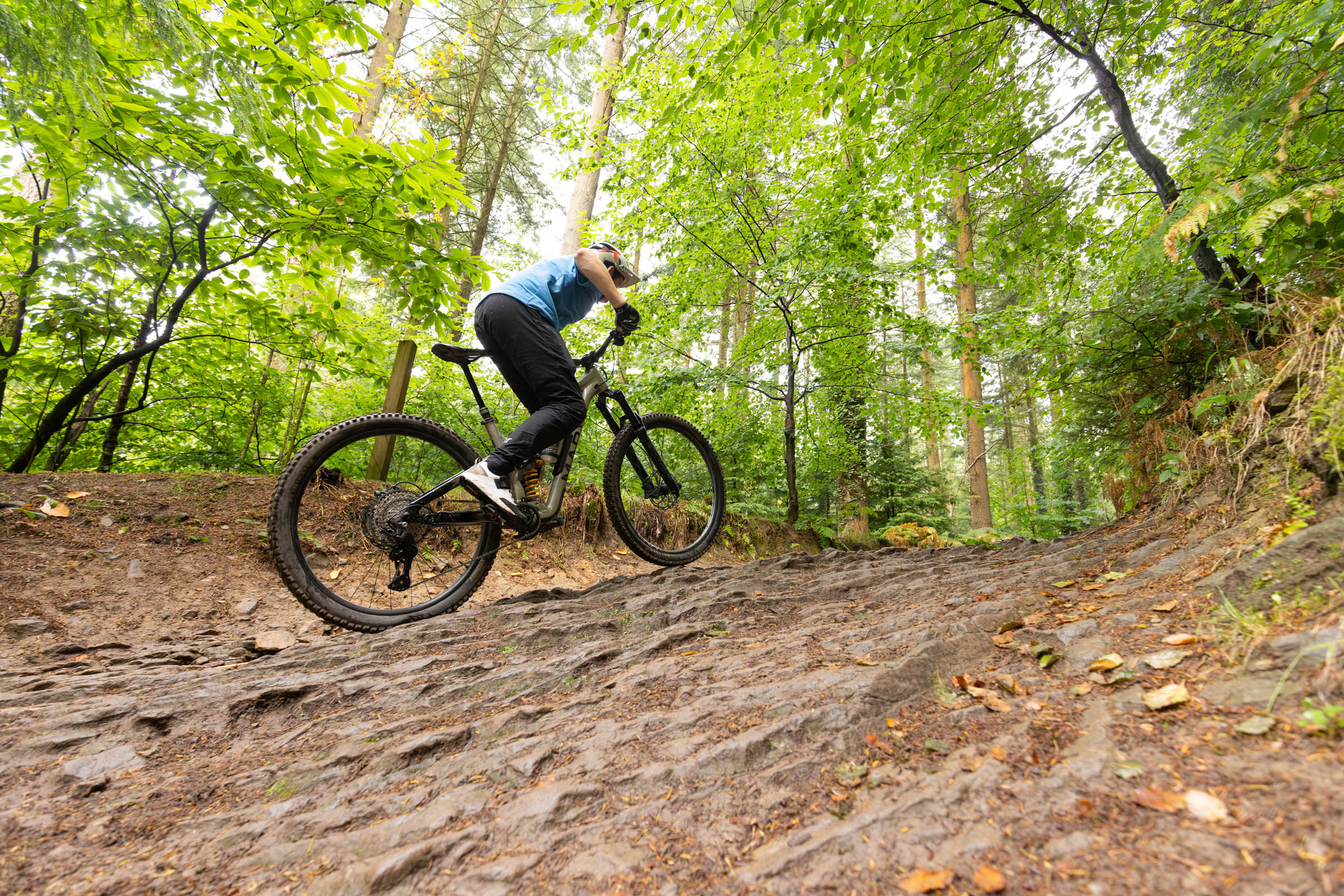 Mountain biker climbing a steep rocky trail on a Marin Alpine Trail XR fitted with Shimano Deore M7200 drivetrain.