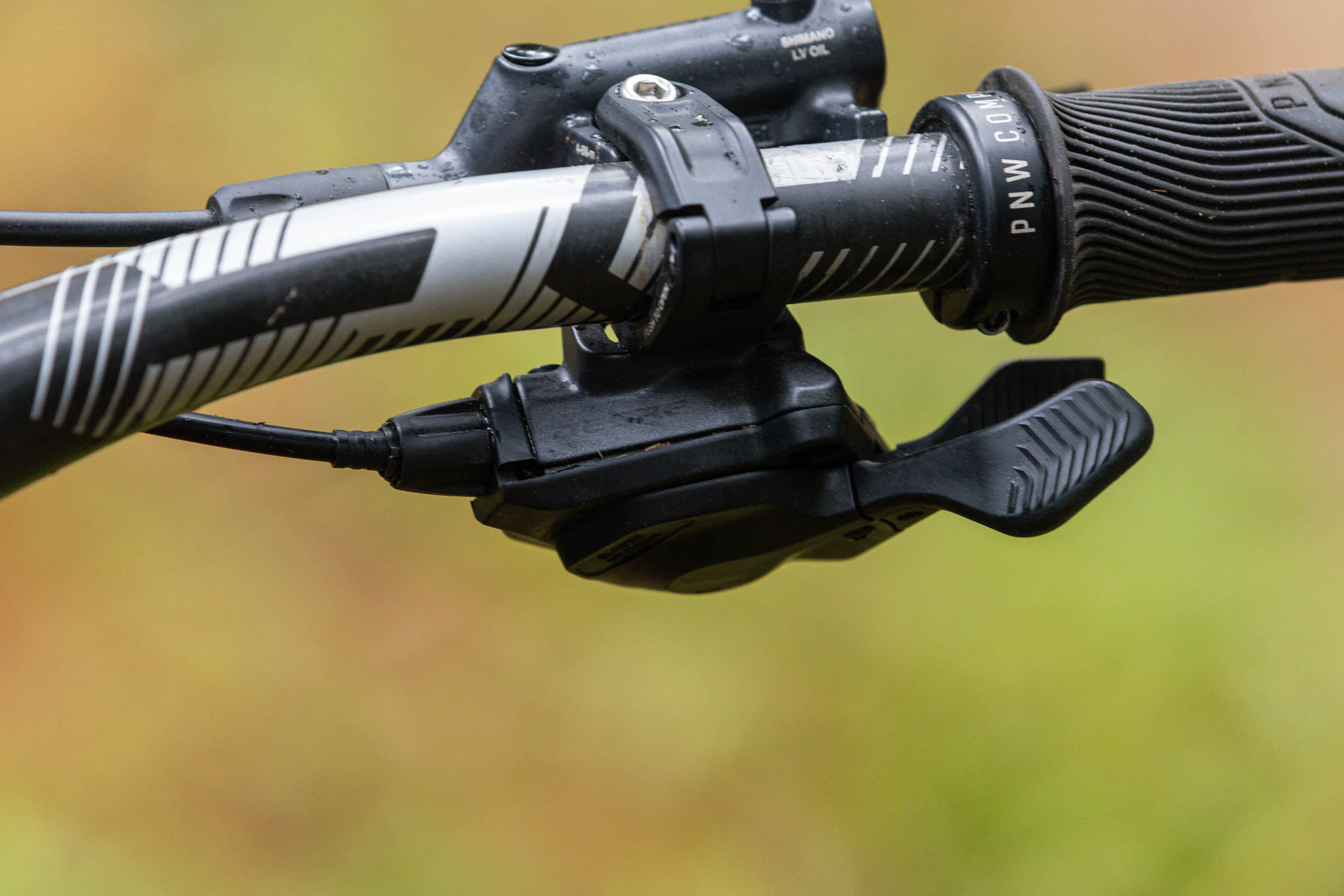 Close-up of a Shimano Deore SL-M6200 mechanical mountain bike shifter mounted beside a Shimano brake lever.