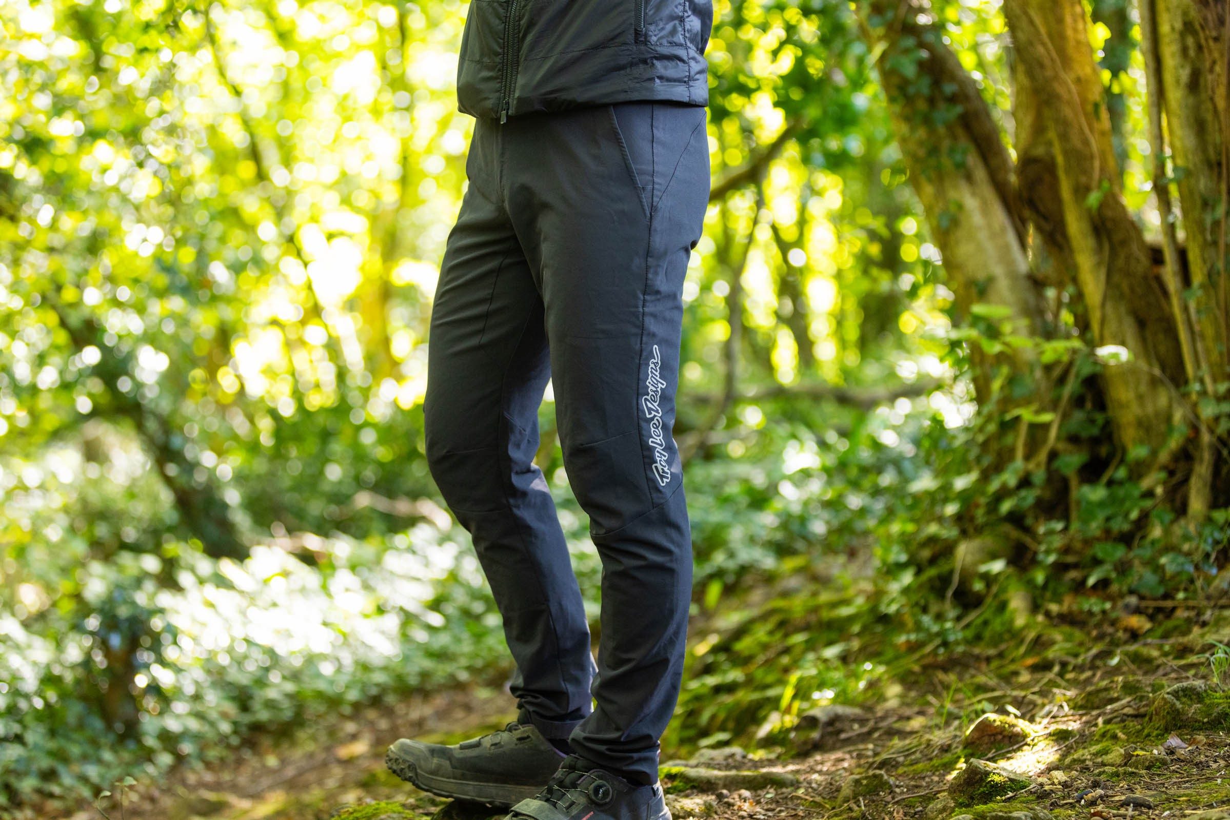 Rider stood wearing the Troy Lee Designs Skyline Superlyte pants in the woods.