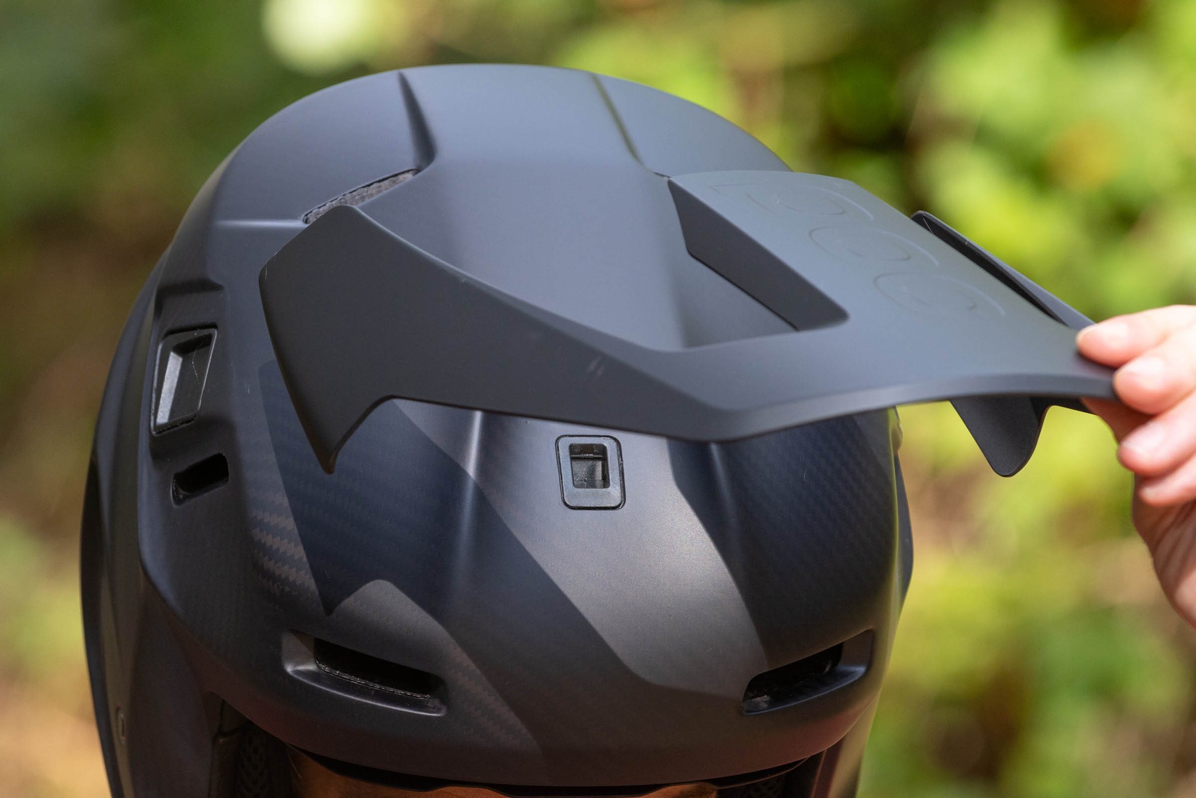 POC's Barocon Carbon full-face helmet features a magnetic peak which is shown here being disconnected from the helmet.