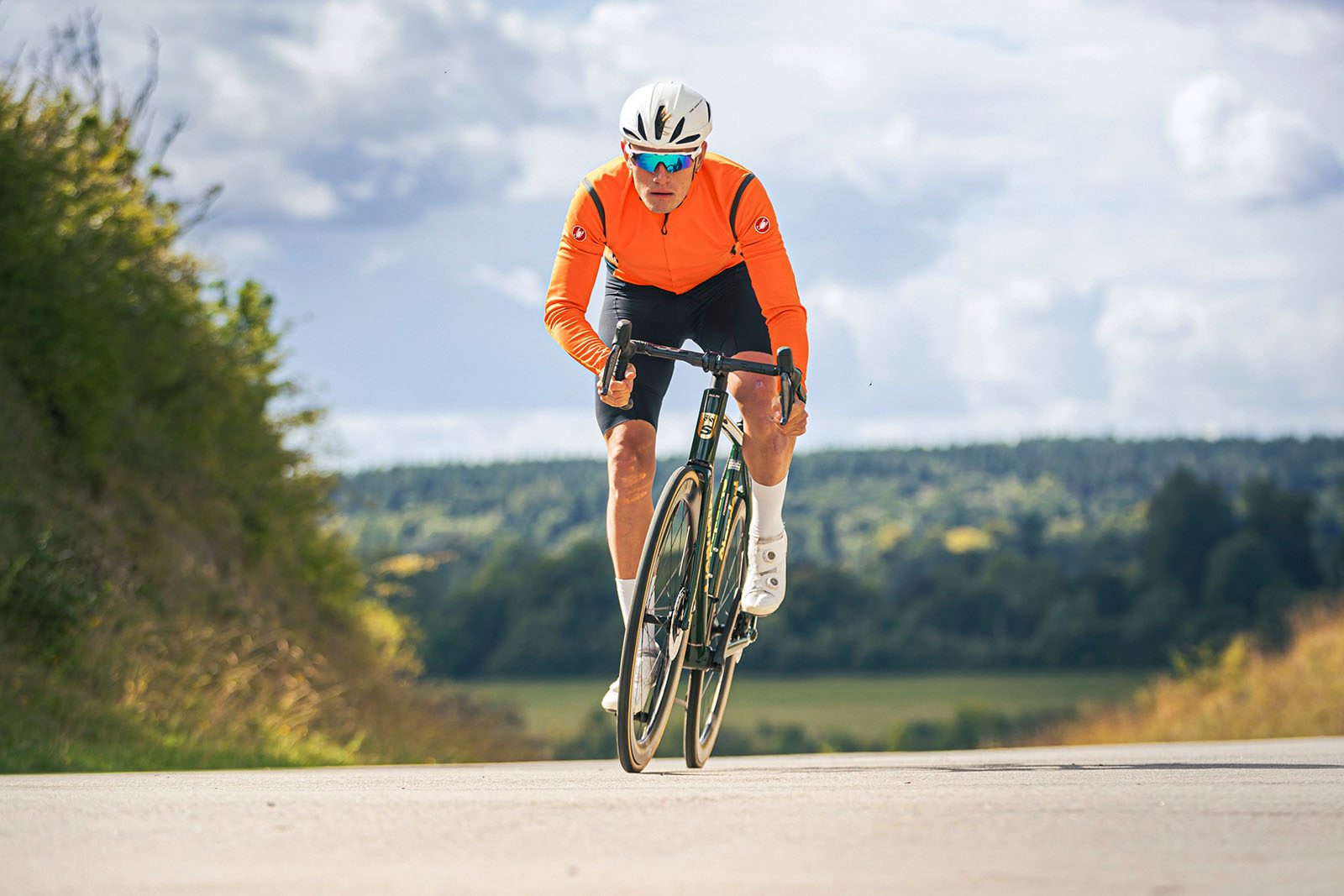 Male cyclist in orange top riding the Standert Kreissäge RS road bike