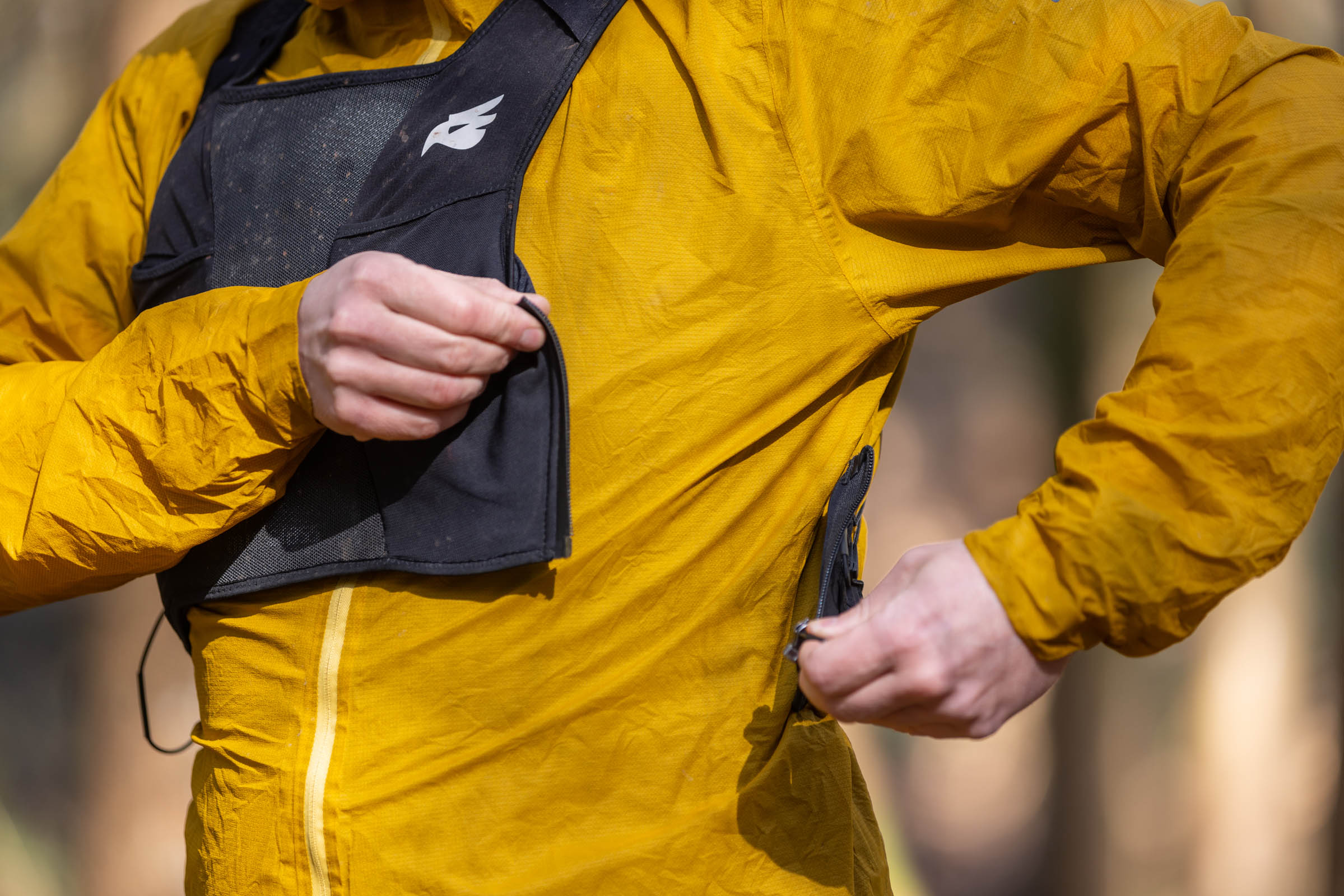 Rider adjusting the side zip of the Bluegrass Venture Vest while holding the front panel.