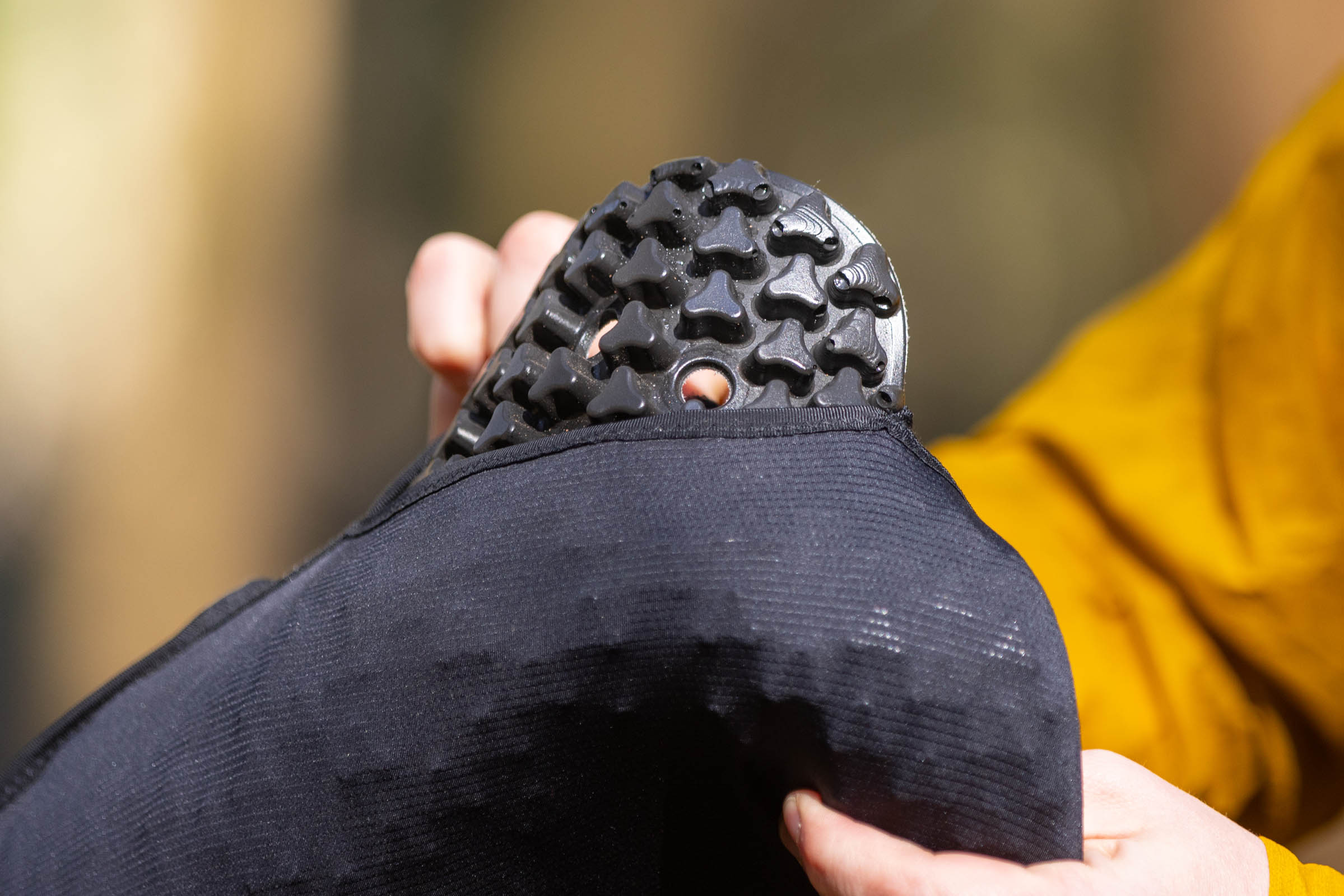 Close-up of a black perforated protective armour insert being pulled from the Bluegrass Venture Vest.