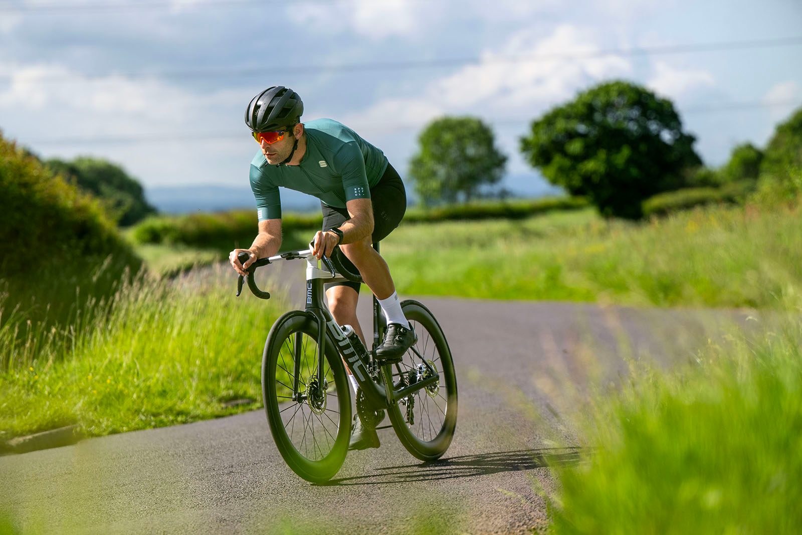 Male cyclist in green top riding the BMC Teammachine R 01 LTD road race bike
