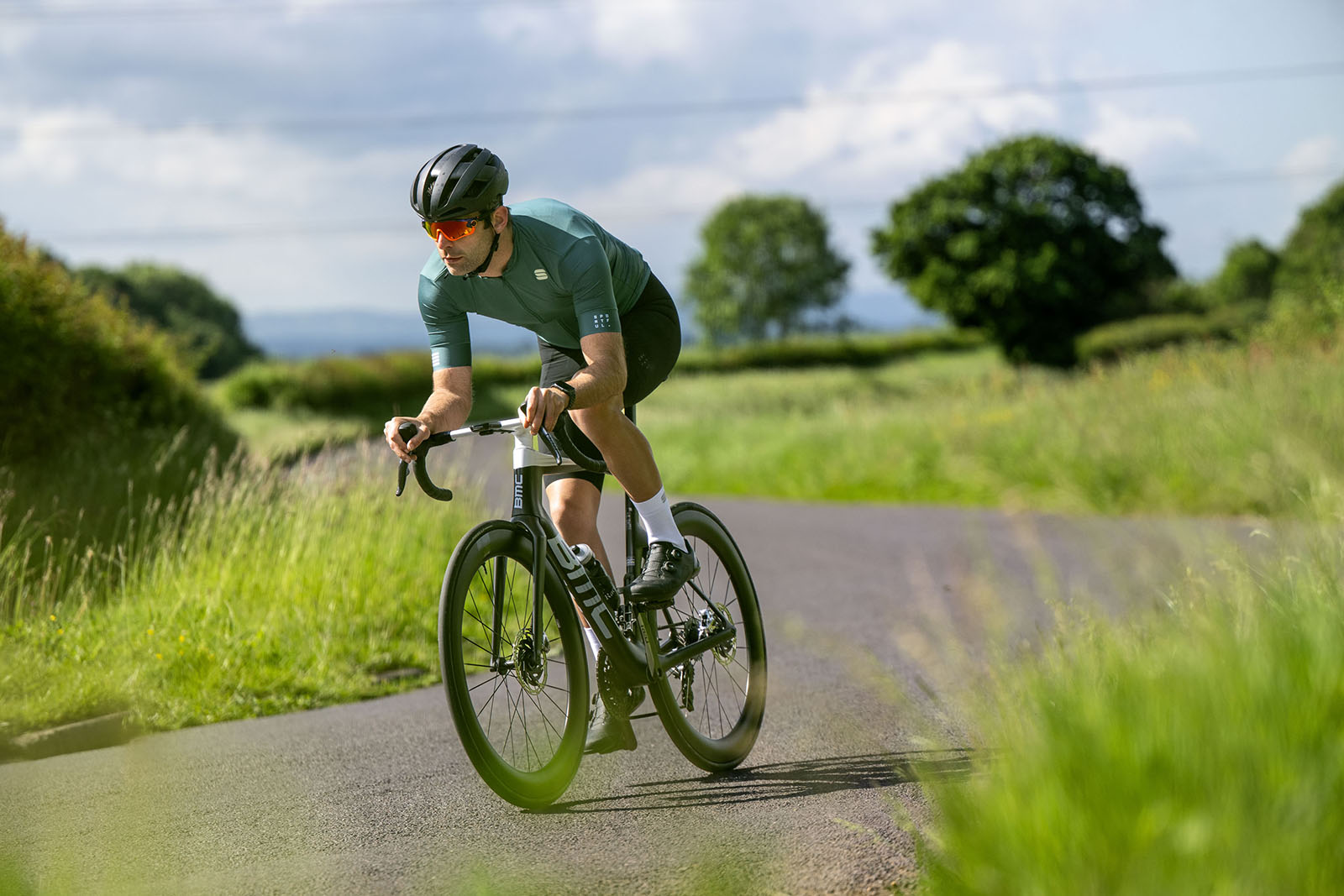 Male cyclist in green top riding the BMC Teammachine R 01 LTD road race bike