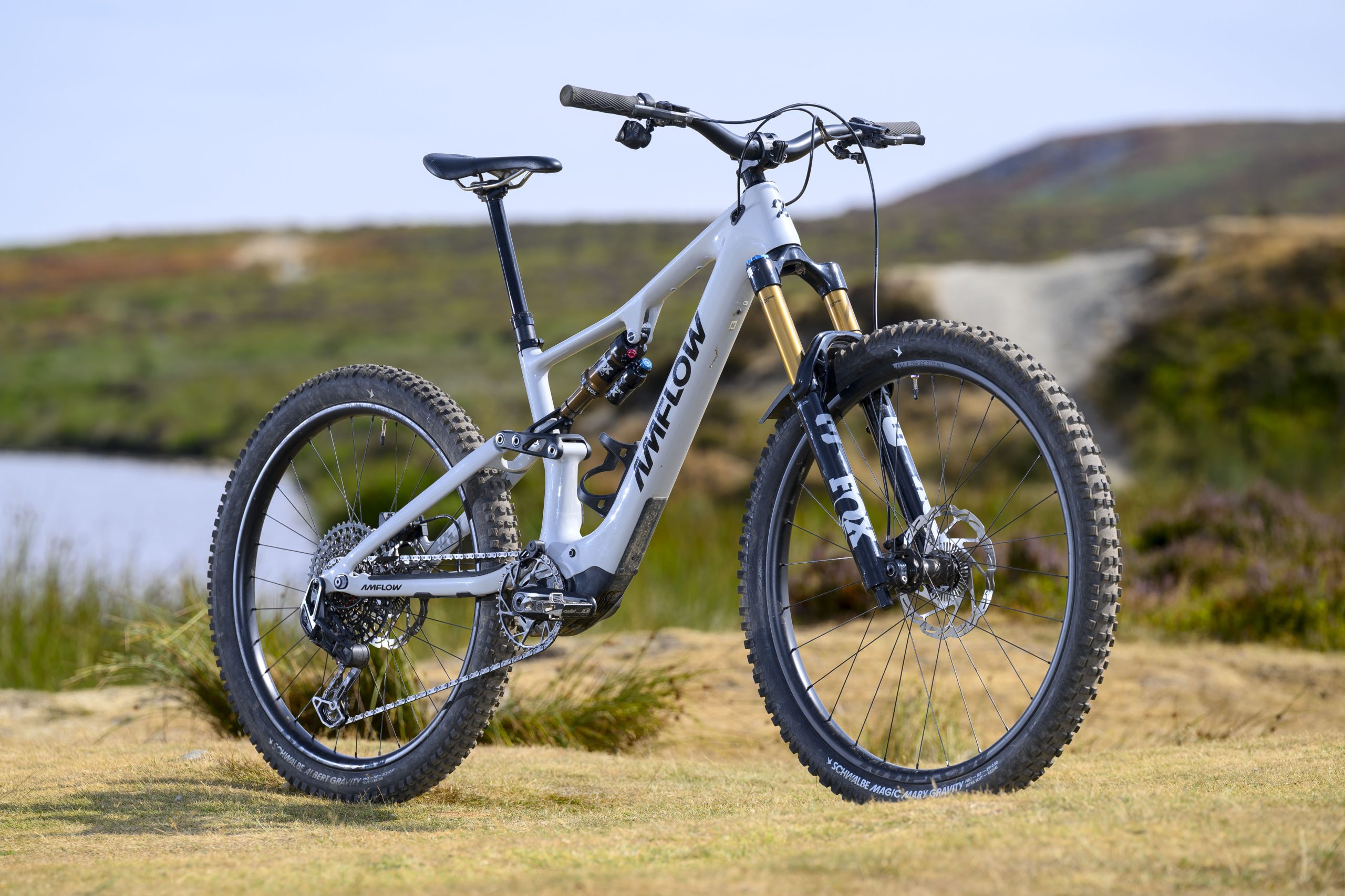 White Amflow PX Carbon Pro electric mountain bike shown from a front three-quarter angle with Fox Factory suspension and carbon wheels