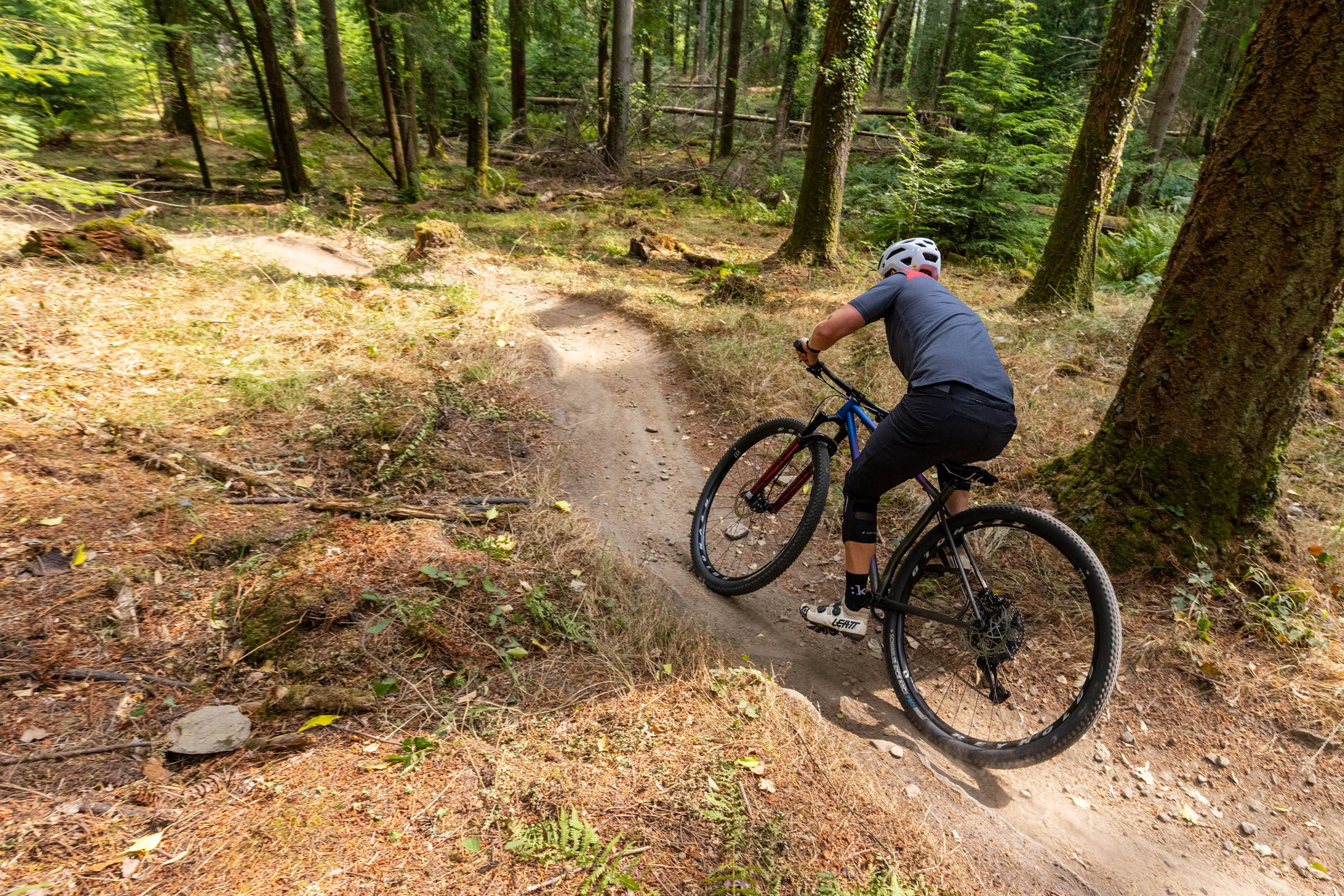 Rider turning the Sour Cycles Pasta Party 32 through a tight bend on a forest trail.