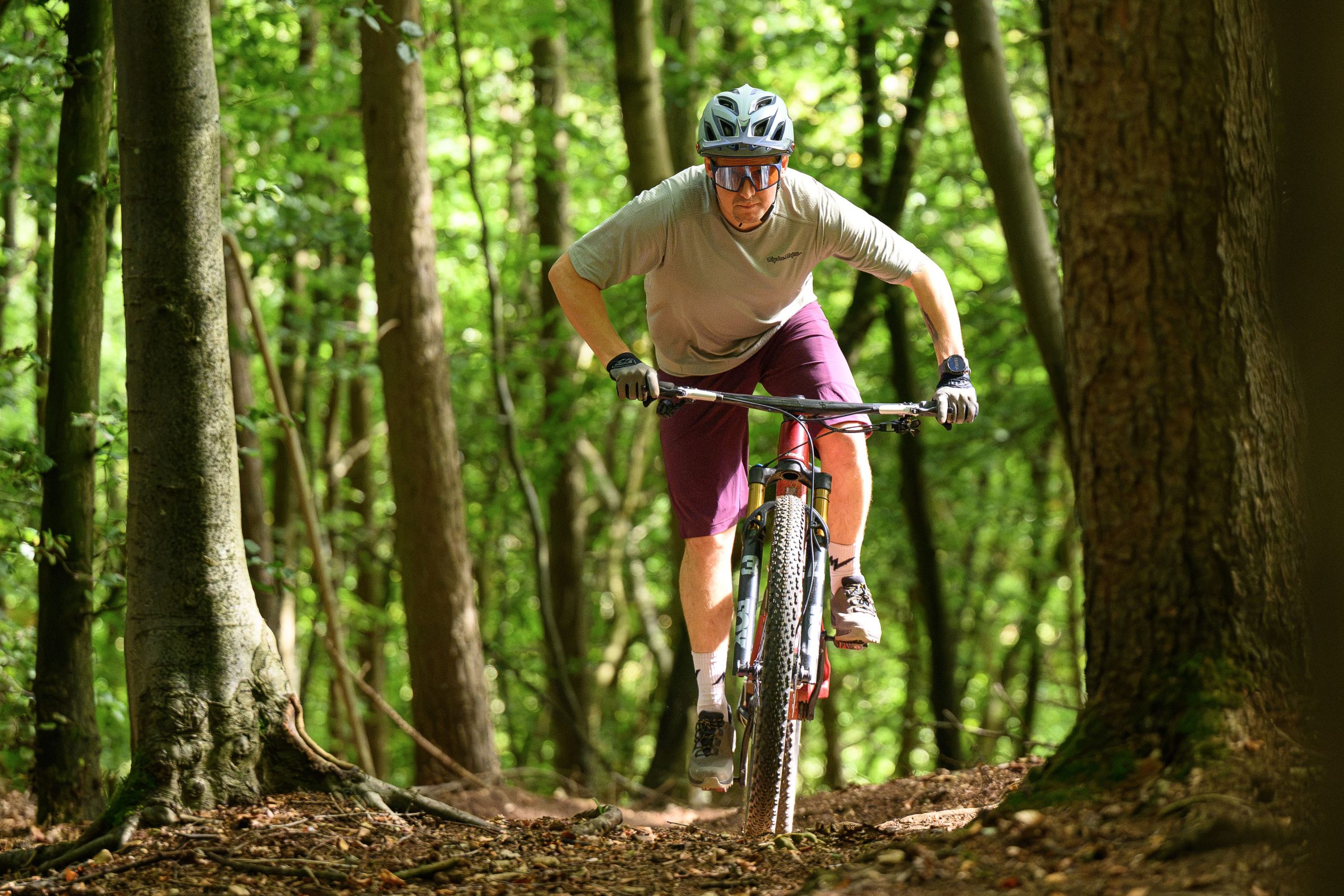 Rider stood up, out of the saddle pedalling uphill aboard the Orbea Oiz.