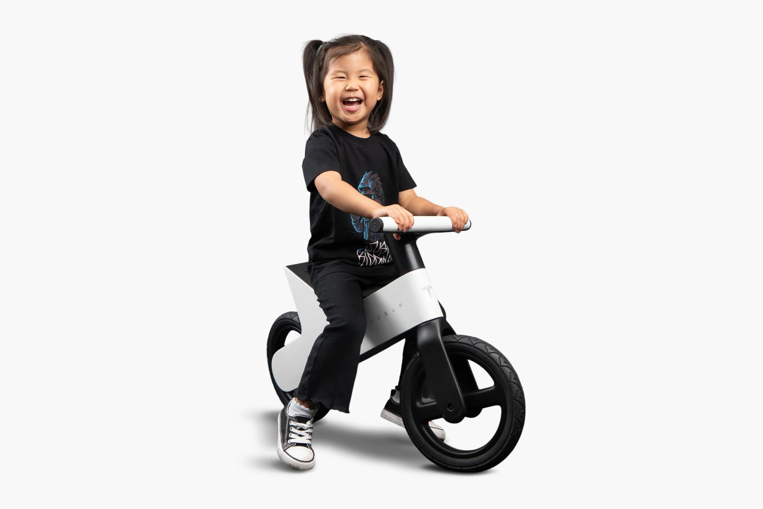Girl riding Tesla balance bike.