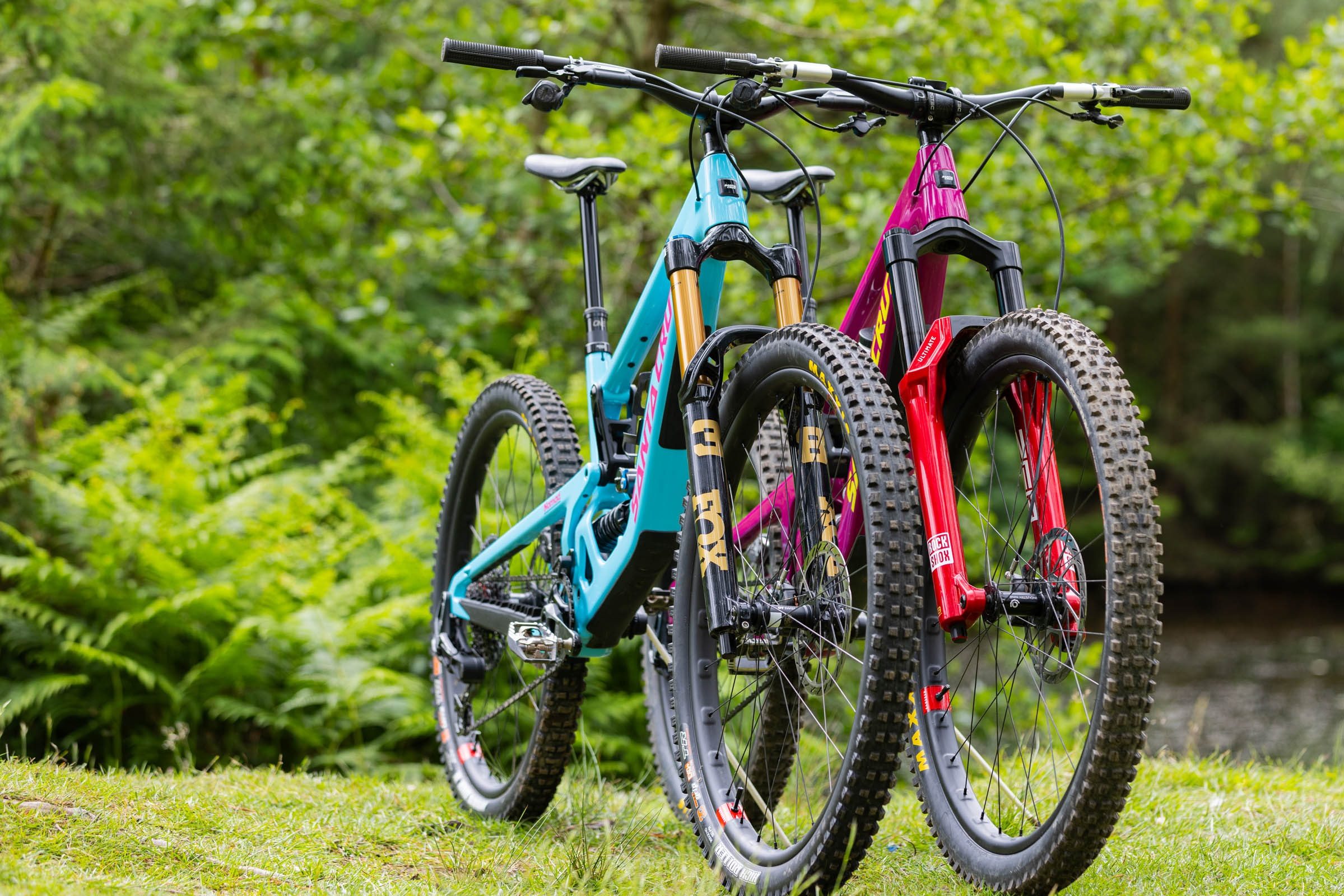 Two bikes stood side by side, one with a RockShox ZEB suspension fork, one with a Fox 38 suspension fork.