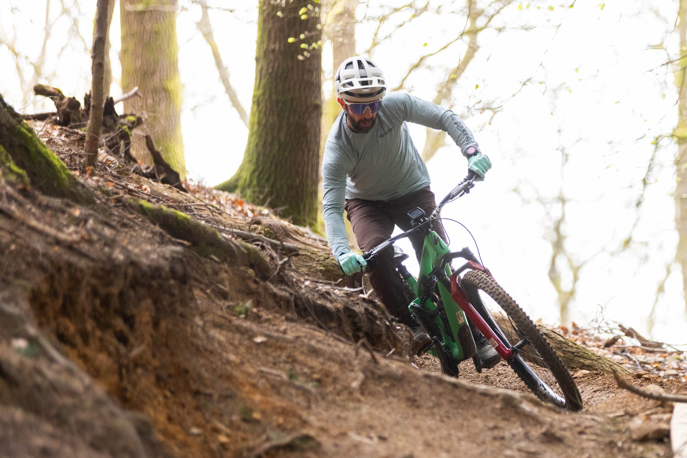 Rider turning around a lefthand singletrack corner.
