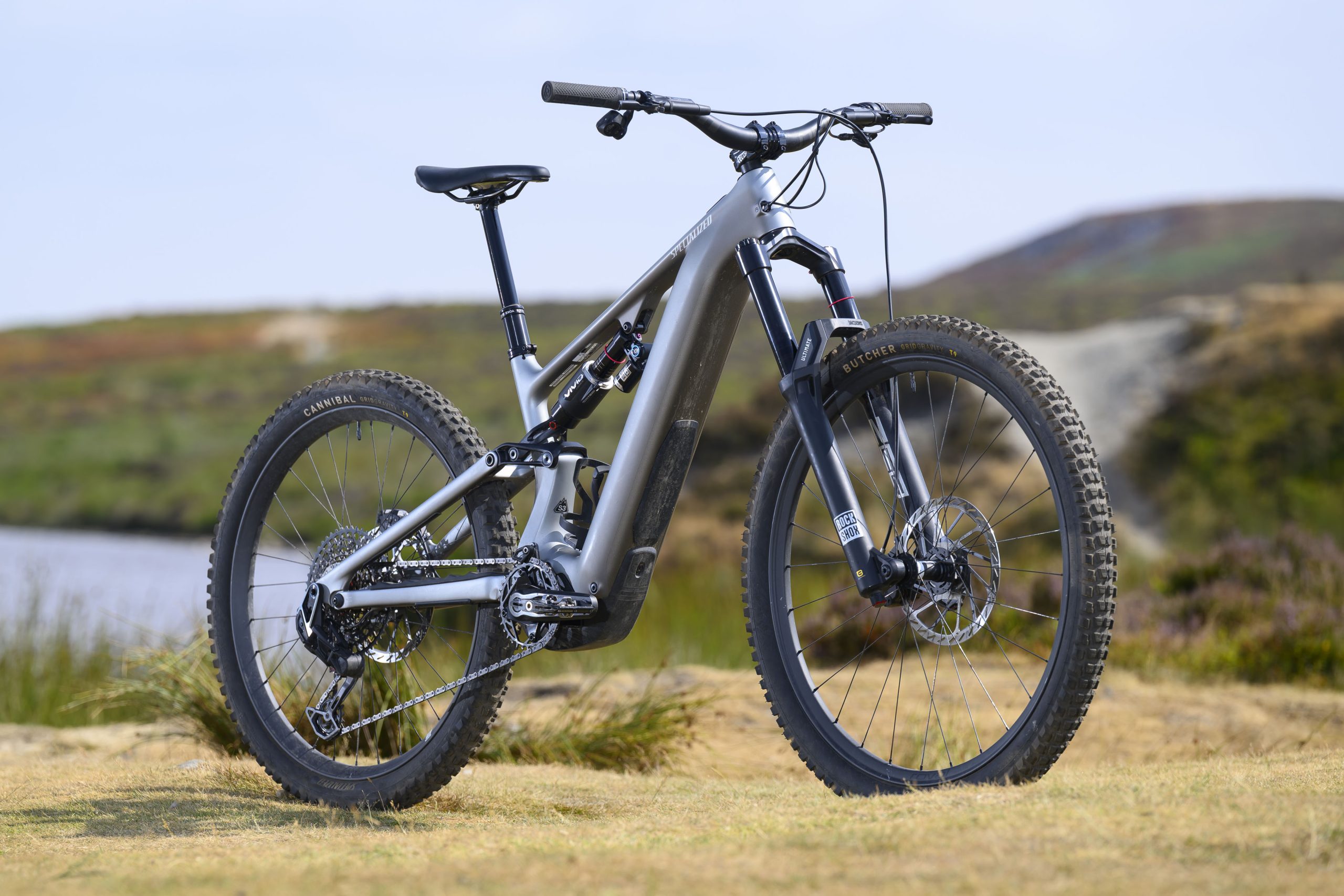 Silver Specialized Levo 4 EVO Pro electric mountain bike shown from the front three-quarter angle with mixed wheels and RockShox suspension