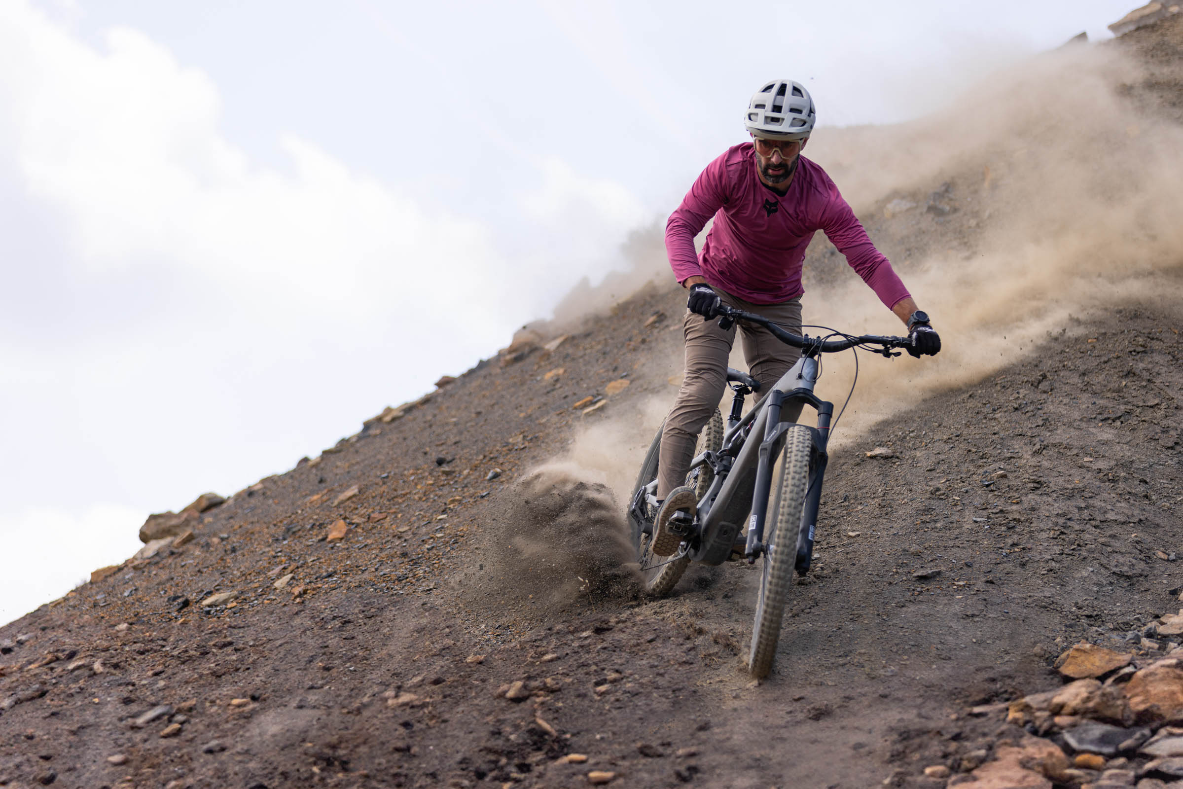 Rider descends a steep, loose and dusty slope on the Specialized Levo 4 EVO Pro eMTB