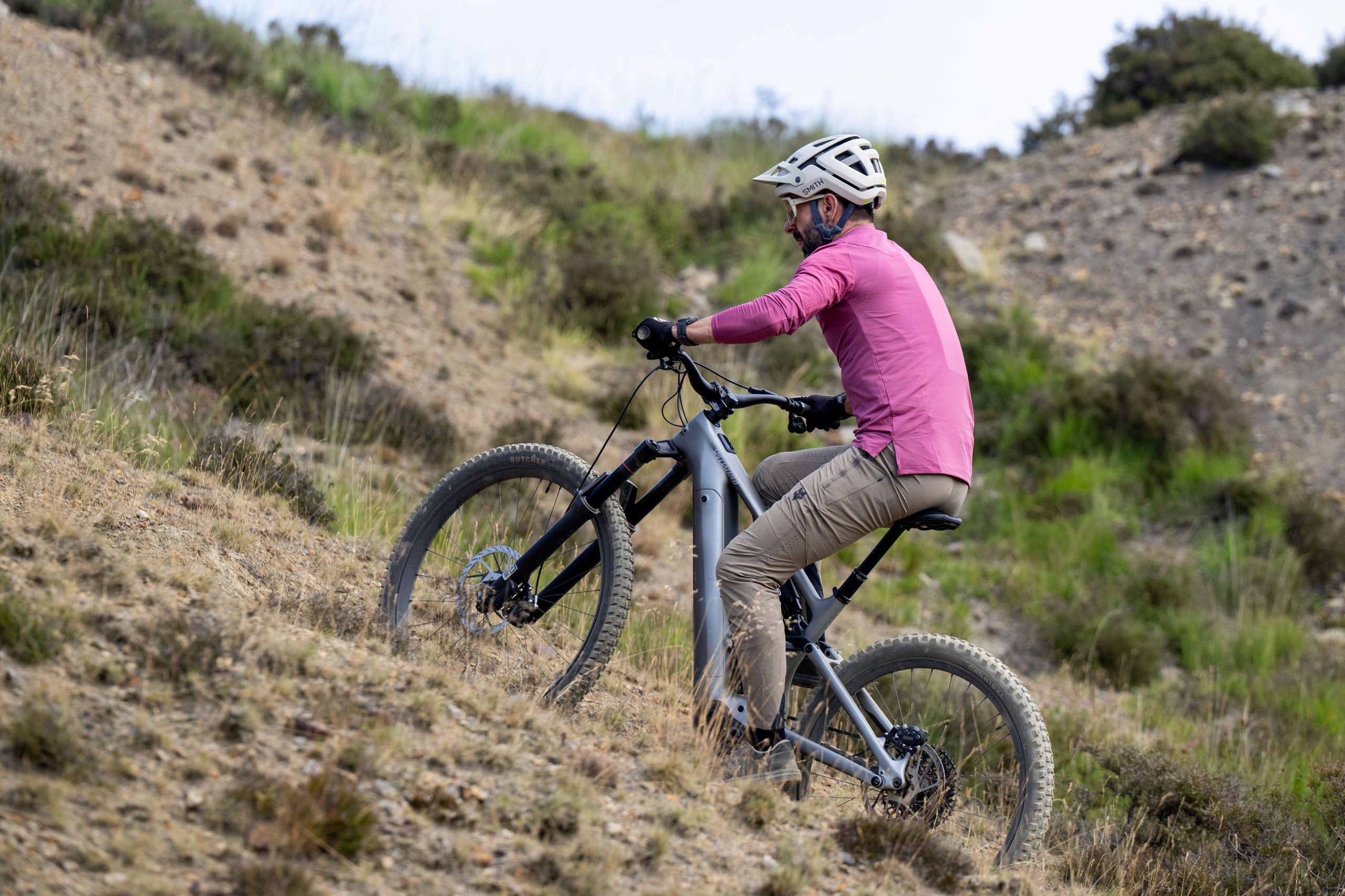 Rider climbing a steep loose trail on a silver Specialized Levo 4 EVO Pro electric mountain bike