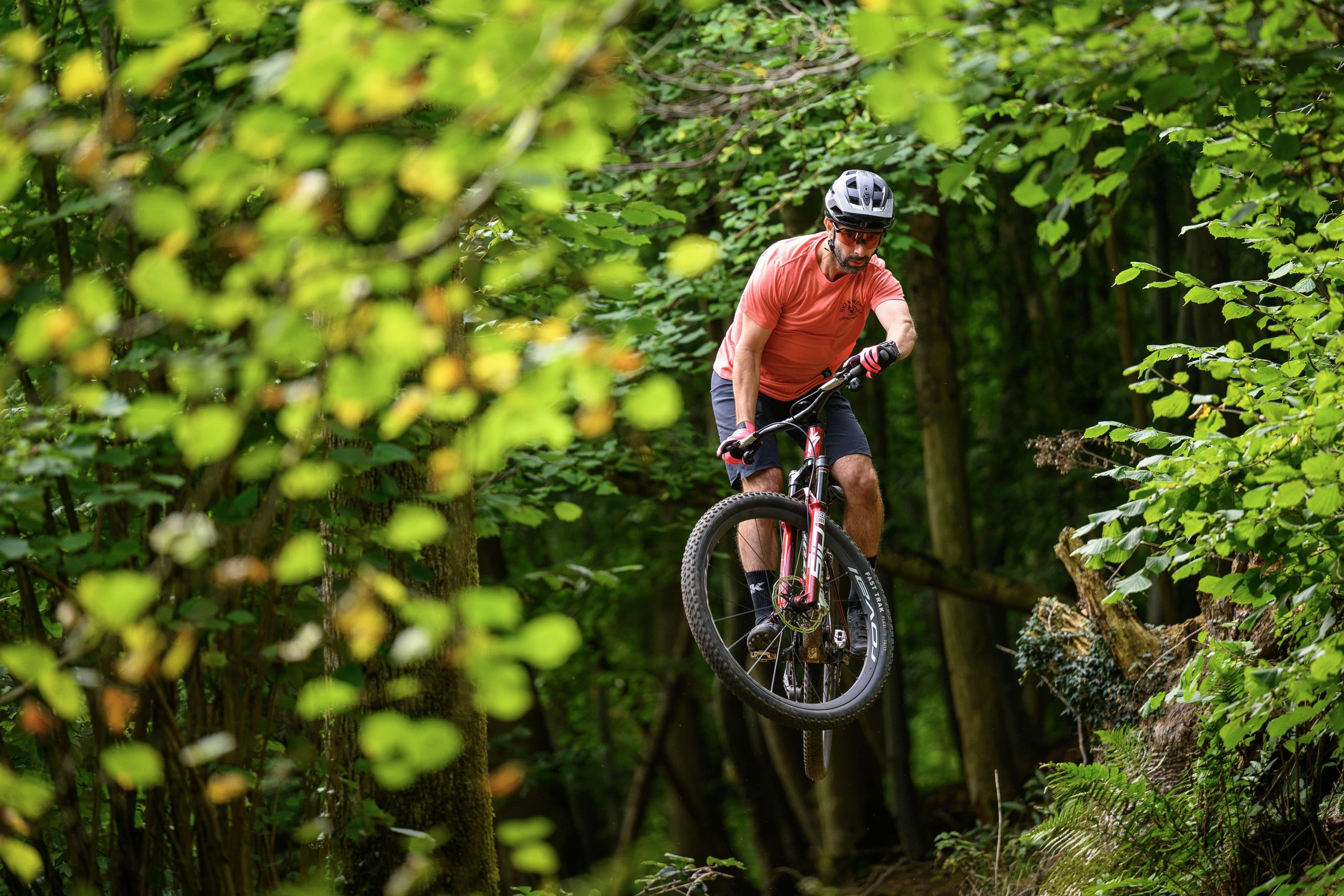 Rider in red t-shirt jumping the Specialized Epic 9.