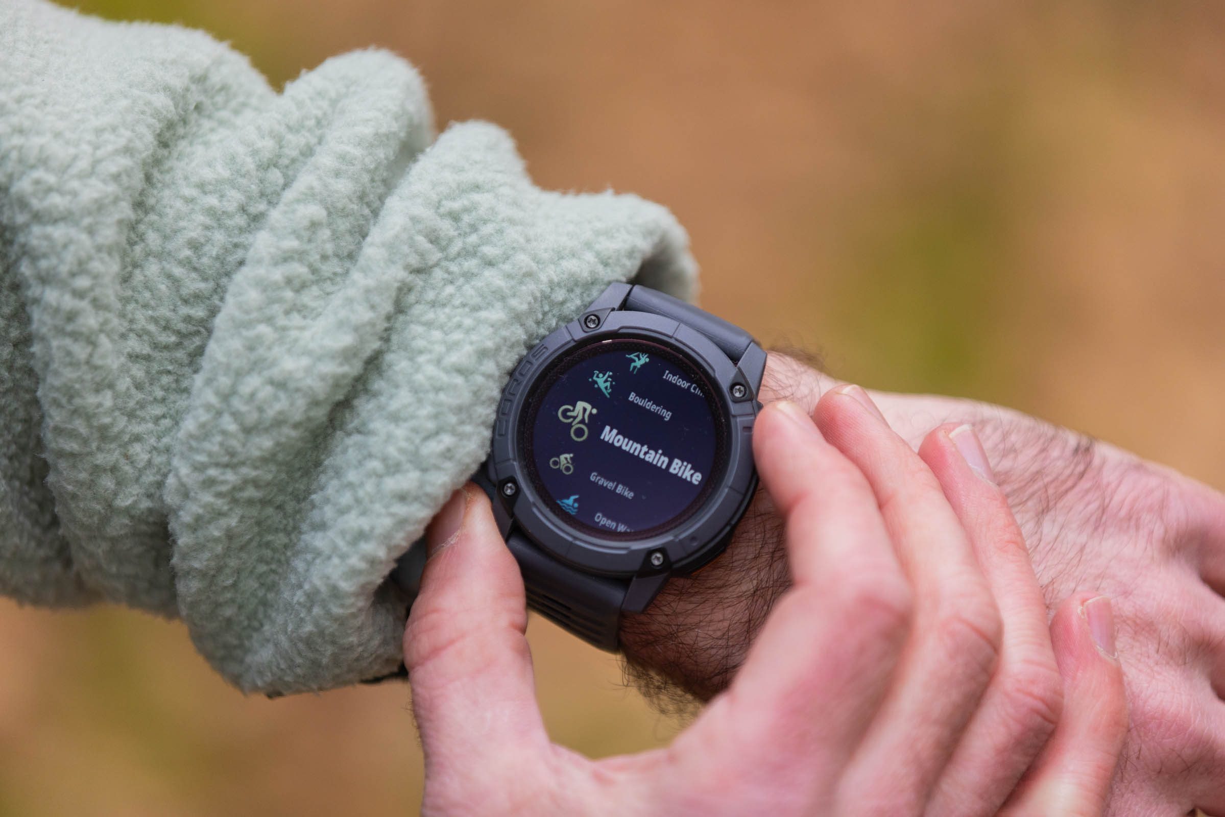 Coros Nomad GPS watch being worn on wrist with user toggling through trackable activities.