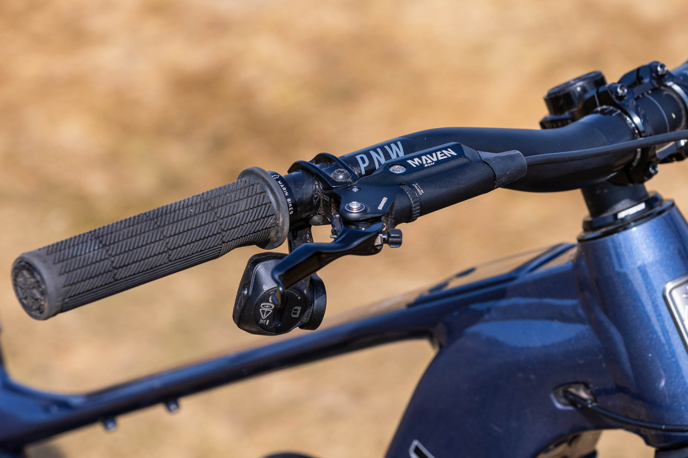 Close-up of the Marin Alpine Trail E XR cockpit showing a SRAM Maven Silver brake lever, control pod and PNW handlebar