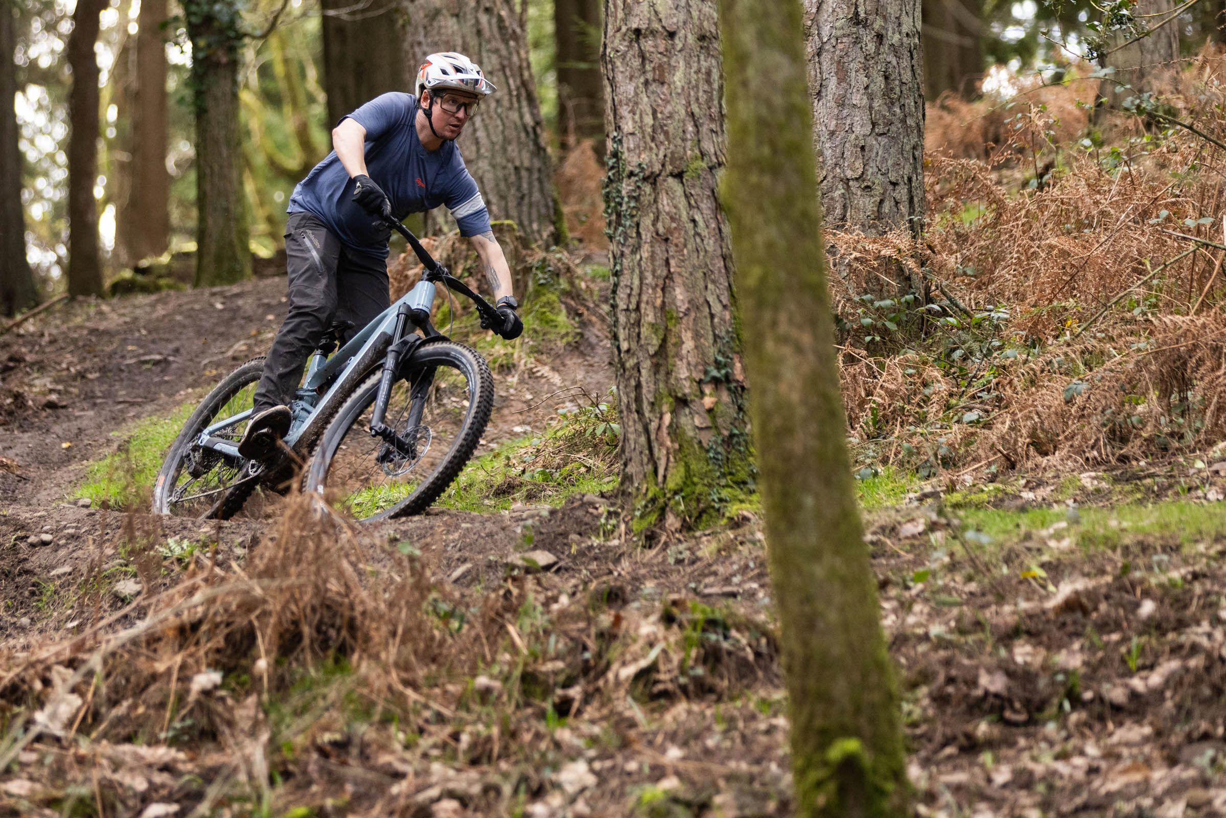 Rider cornering the Raymon Ravor Ultra e-MTB on a woodland mountain bike trail