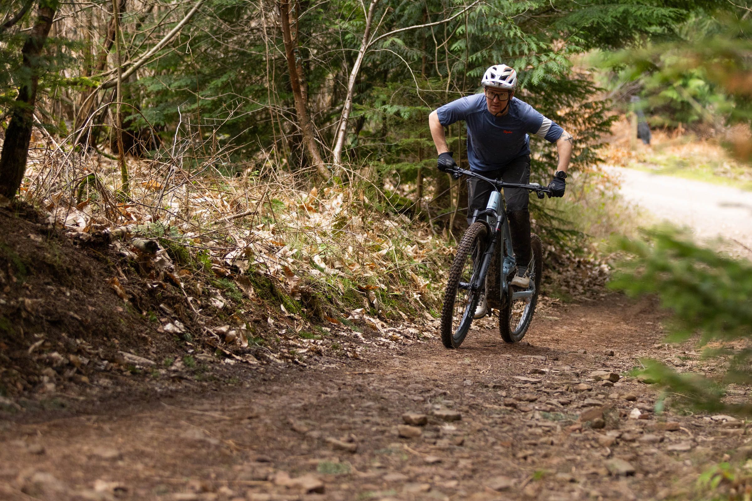 Rider climbing a rocky woodland trail on the Raymon Ravor Ultra electric mountain bike