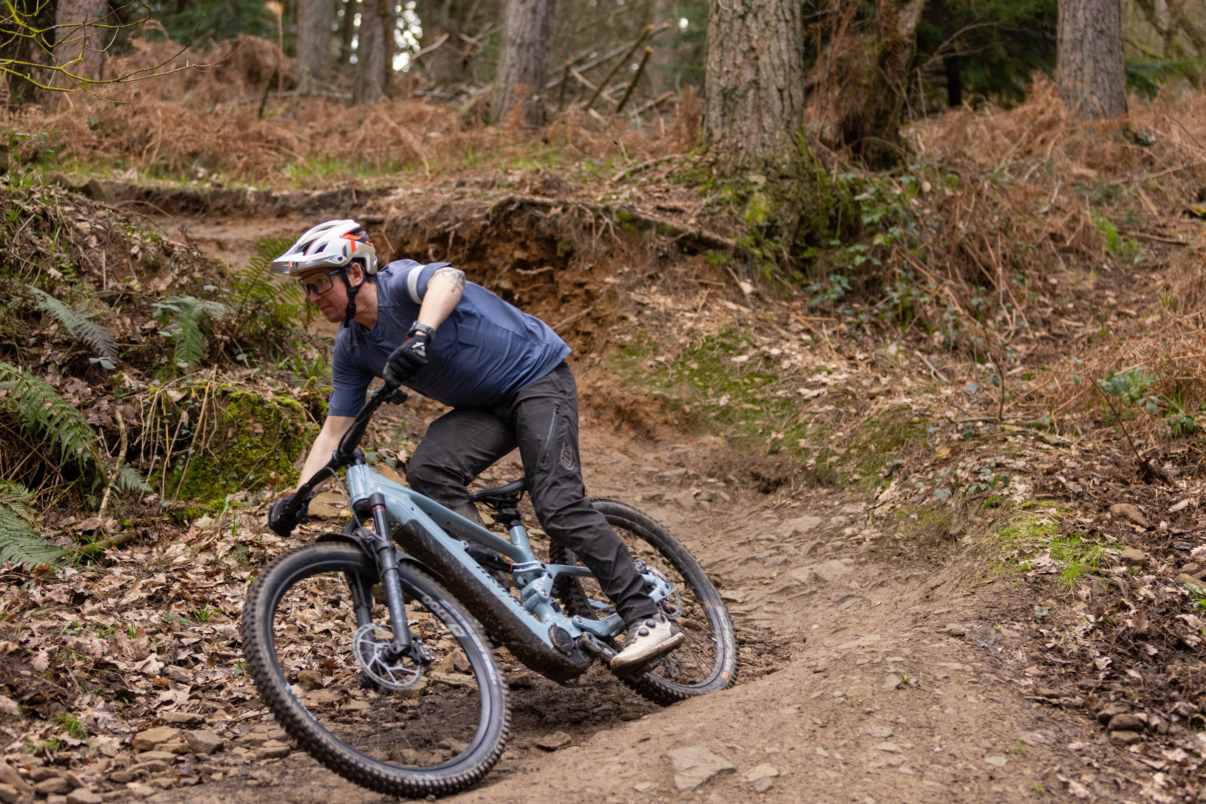 Rider cornering the Raymon Ravor Ultra e-MTB on a rocky woodland trail