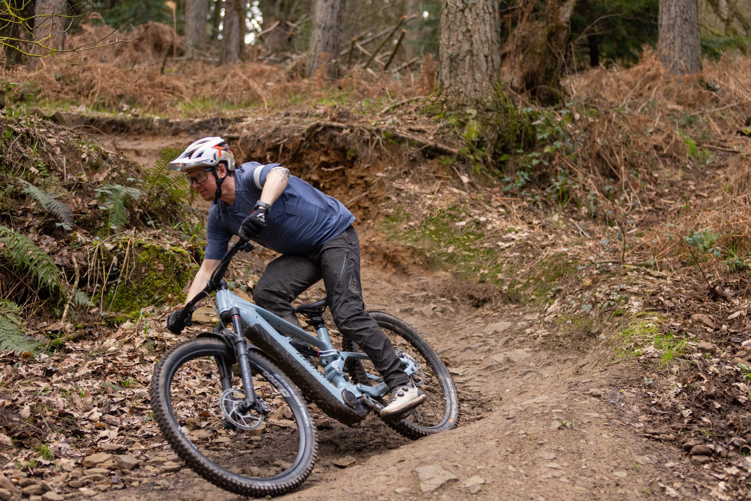 Rider cornering the Raymon Ravor Ultra e-MTB on a rocky woodland trail