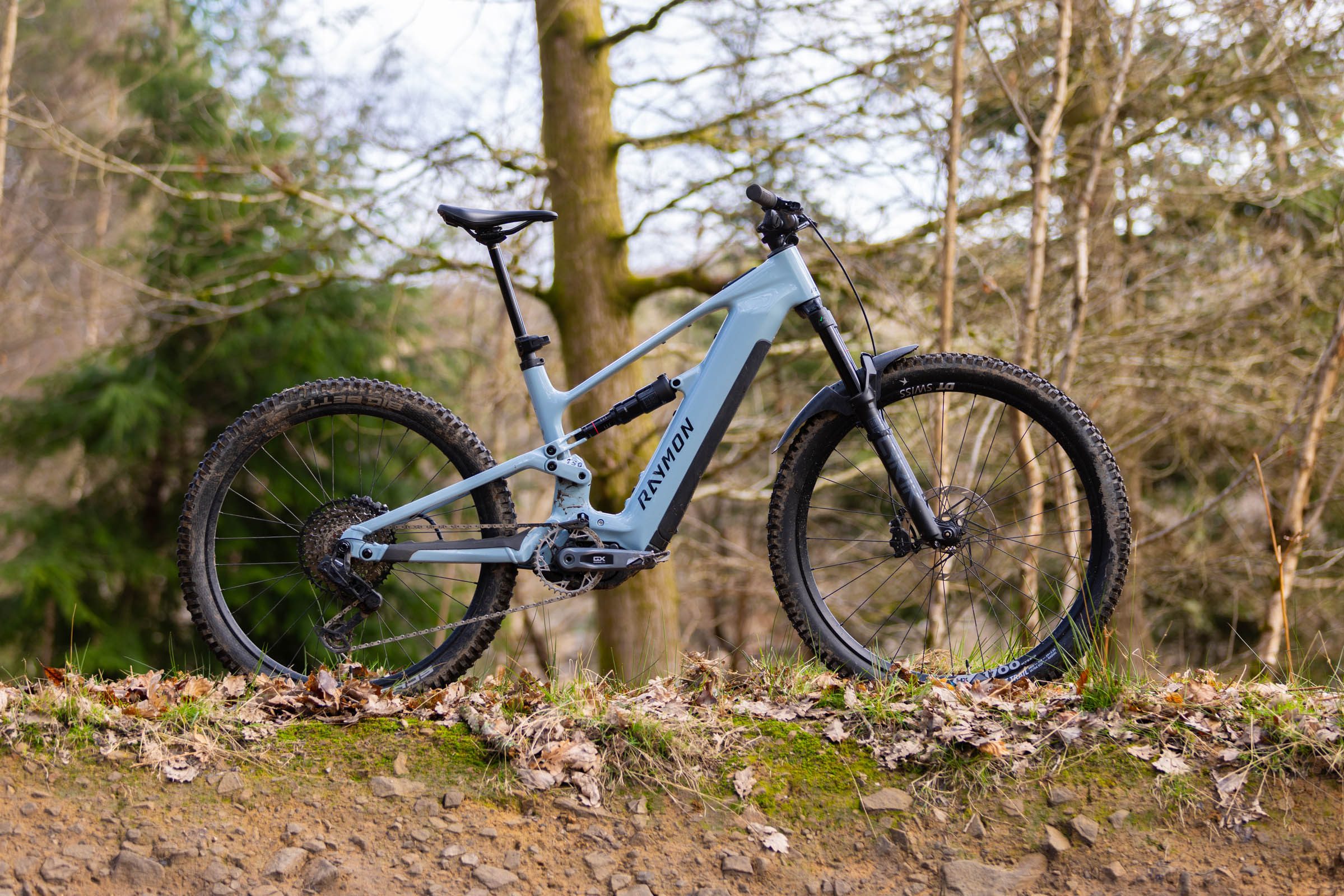 Side-on view of the Raymon Ravor Ultra full-power electric mountain bike in woodland