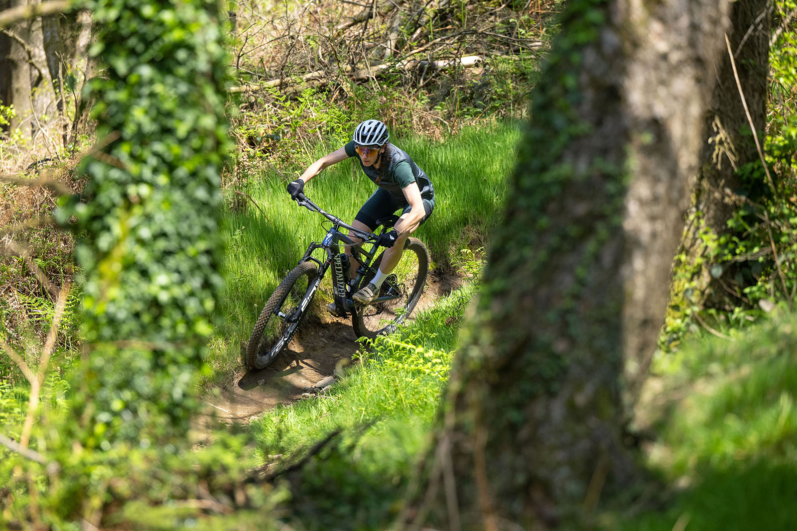 Female rider in blue top riding the Specialized Epic 8 Pro full suspension mountain bike