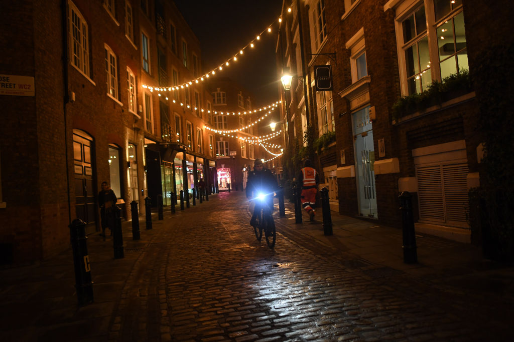 LONDON, ENGLAND - DECEMBER 02: A man is seen cycling through an empty Covent Garden on December 2, 2020 in London, England.