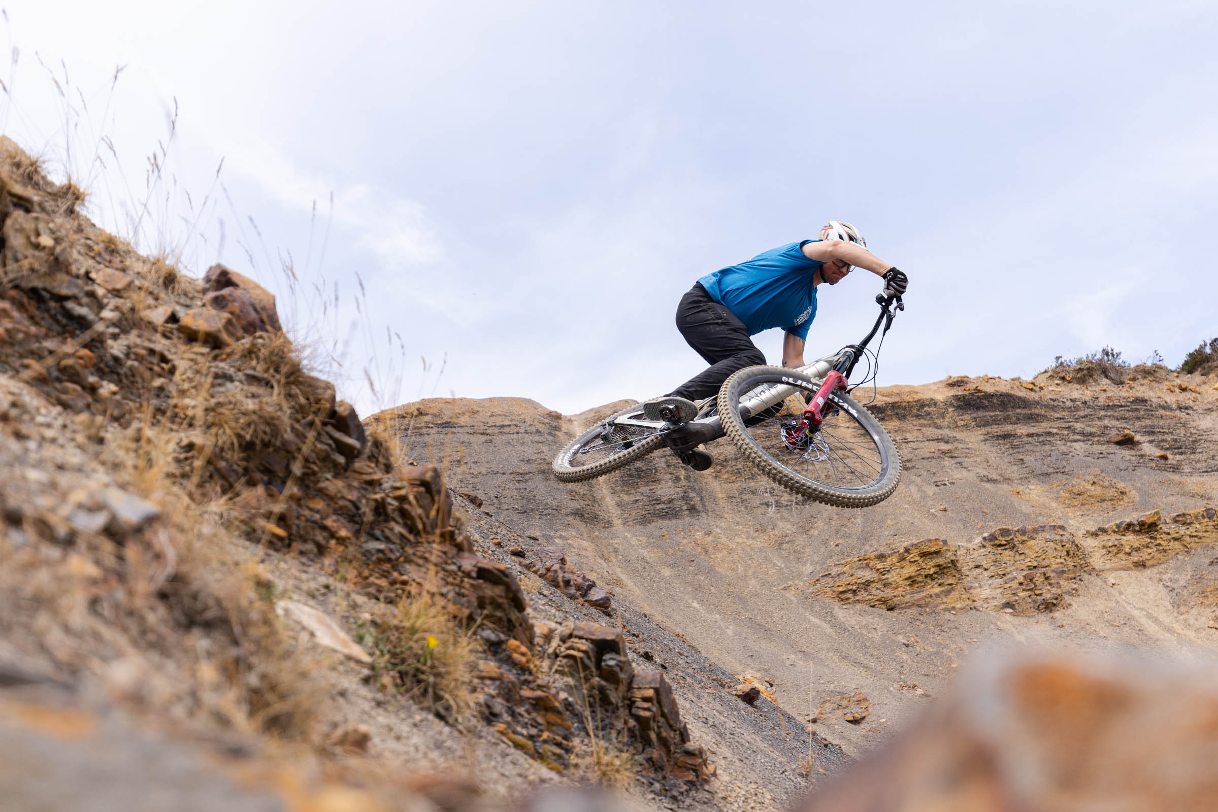 Rider jumping the Atherton S.170E.2 electric mountain bike over rocky terrain.