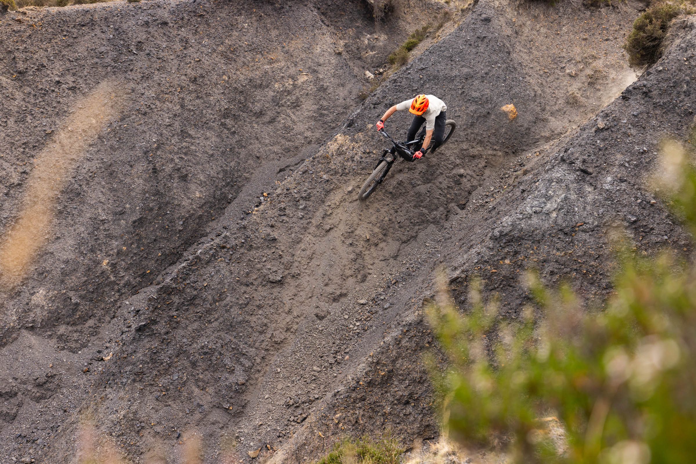 Rider carving across a steep, loose hillside on the Merida Lithos 8000 electric mountain bike