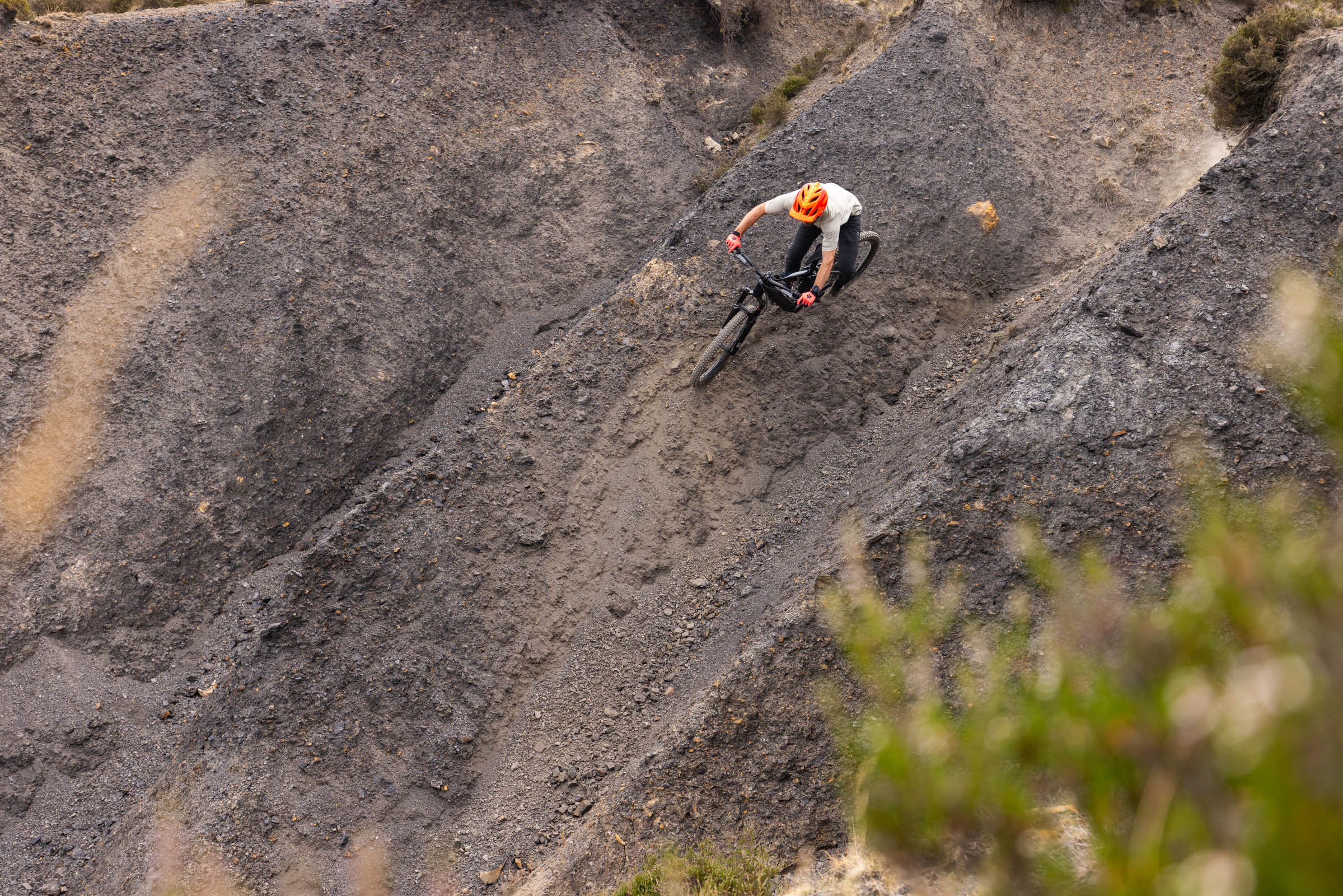 Rider carving across a steep, loose hillside on the Merida Lithos 8000 electric mountain bike