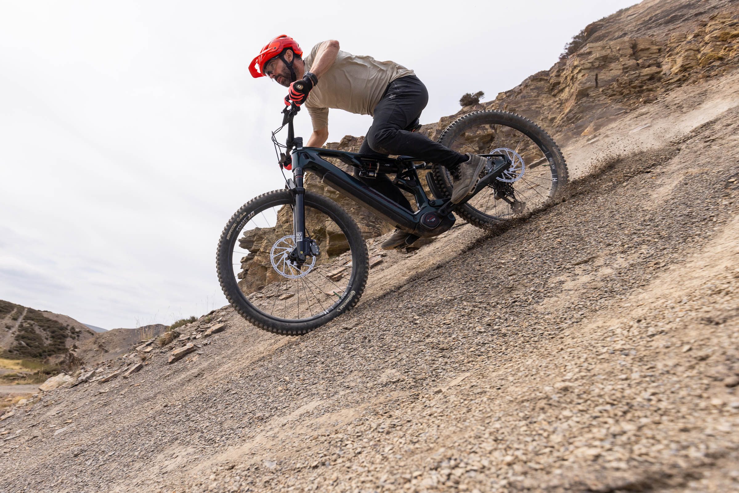 Rider lands the Merida Lithos 8000 hard into a steep, loose compression on a rocky descent