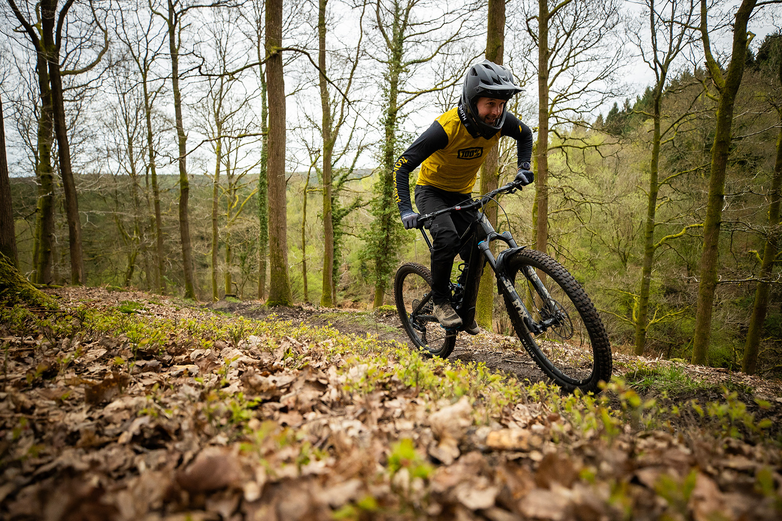 Male rider in yellow top riding the Specialized Turbo Kenevo SL 2 Expert lightweight full suspension mountain electric bike - eMTB