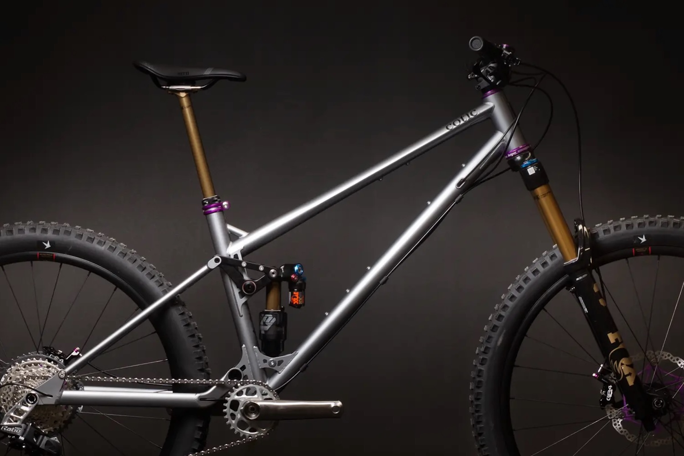 Studio image of the Cotic Jeht Gen 3 mountain bike in matte metal, showing its steel front triangle, linkage-driven rear suspension and mixed-wheel trail-bike layout.