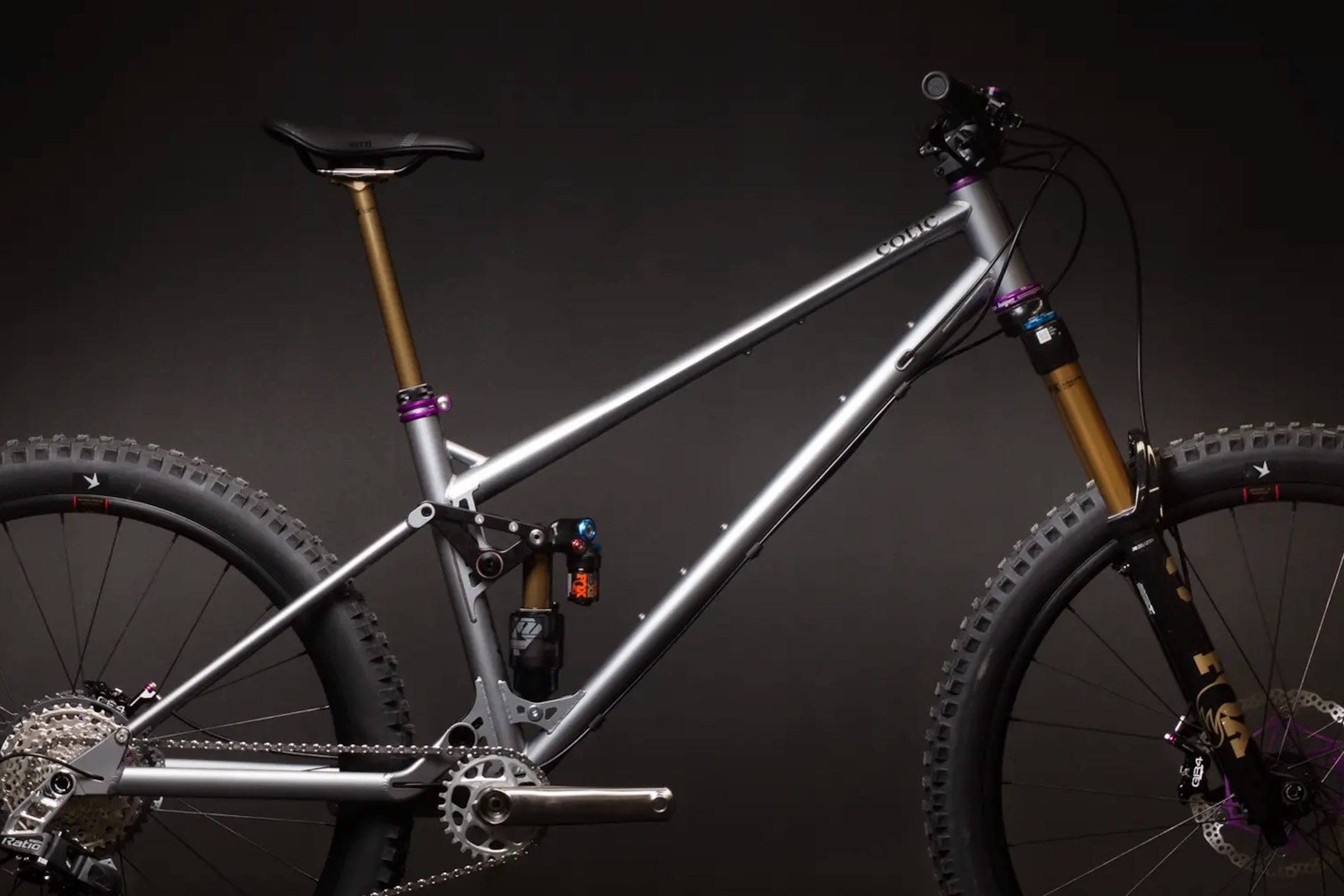 Studio image of the Cotic Jeht Gen 3 mountain bike in matte metal, showing its steel front triangle, linkage-driven rear suspension and mixed-wheel trail-bike layout.