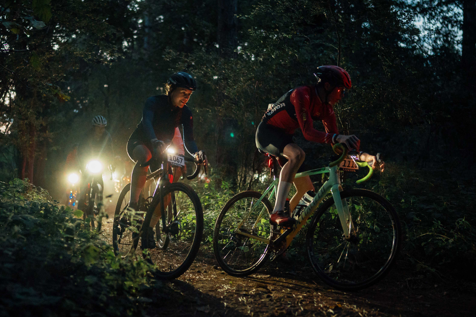 Group of cyclists riding at night in the King's Cup gravel race.