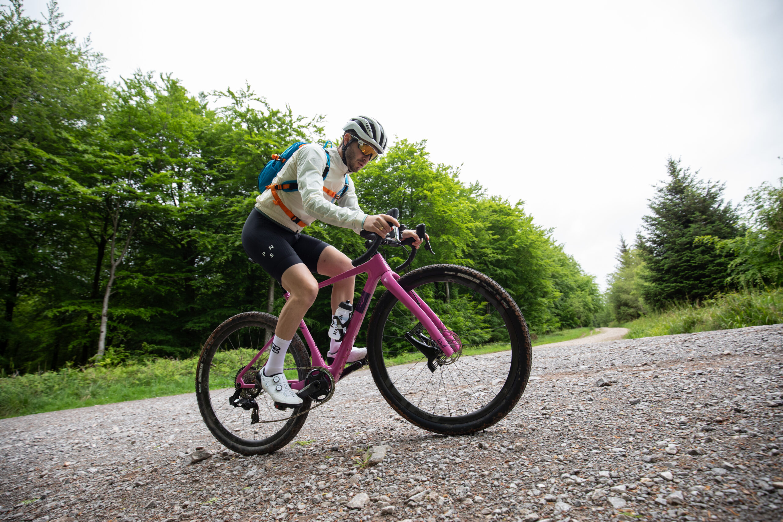 Liam Cahill climbing on gravel incline on pink Lauf gravel bike