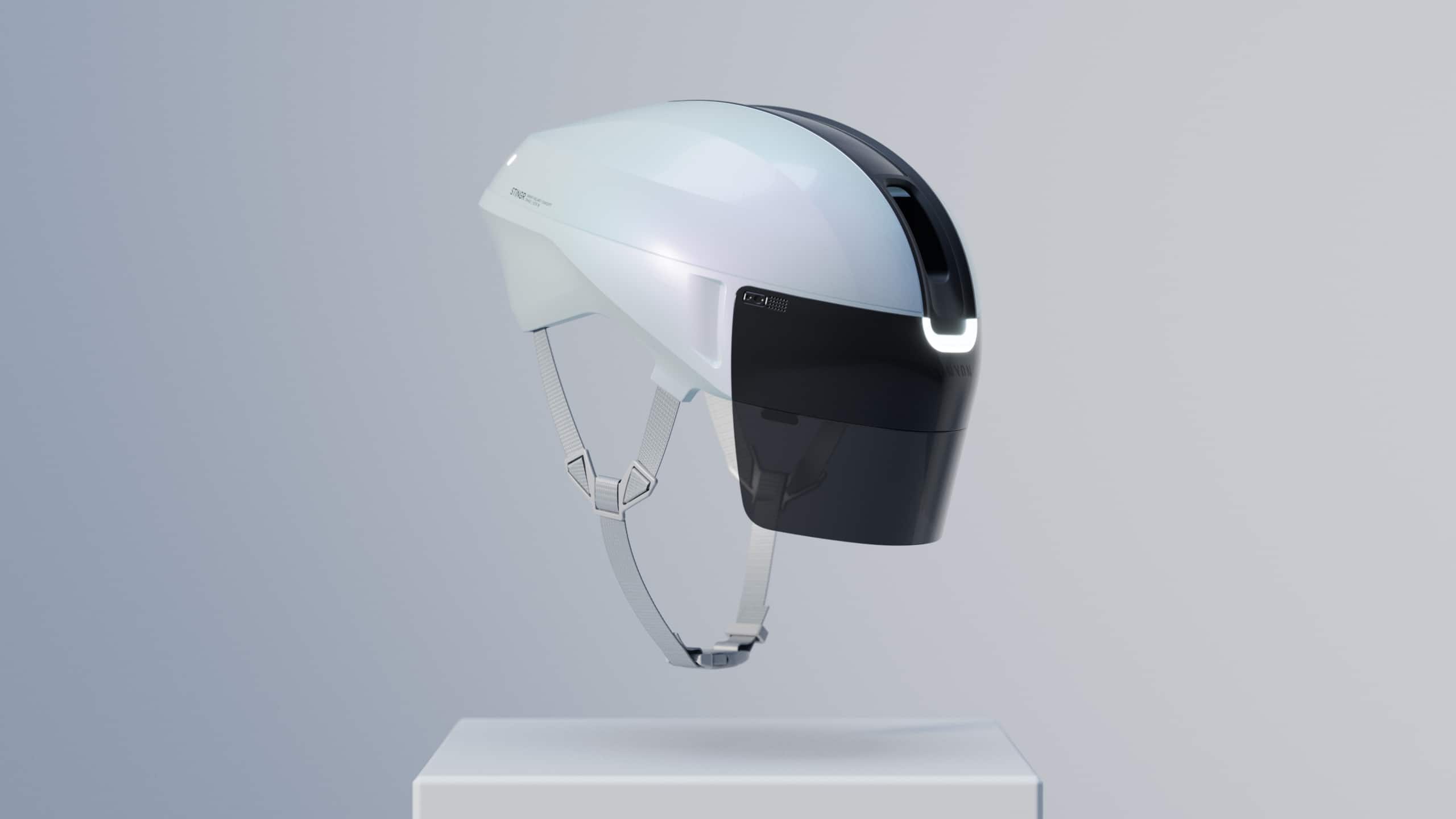 White bike helmet with shiny black face visor suspended in the air over a pedestal